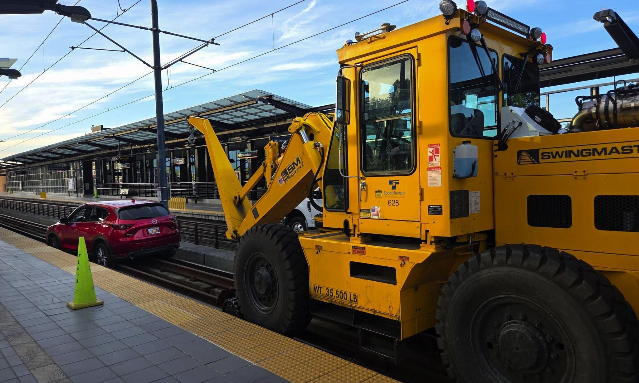 On Tuesday heavy equipment removes a red Mazda from the Mount Baker light-rail platform after its still partly mysterious appearance there. (Provided by Sound Transit)