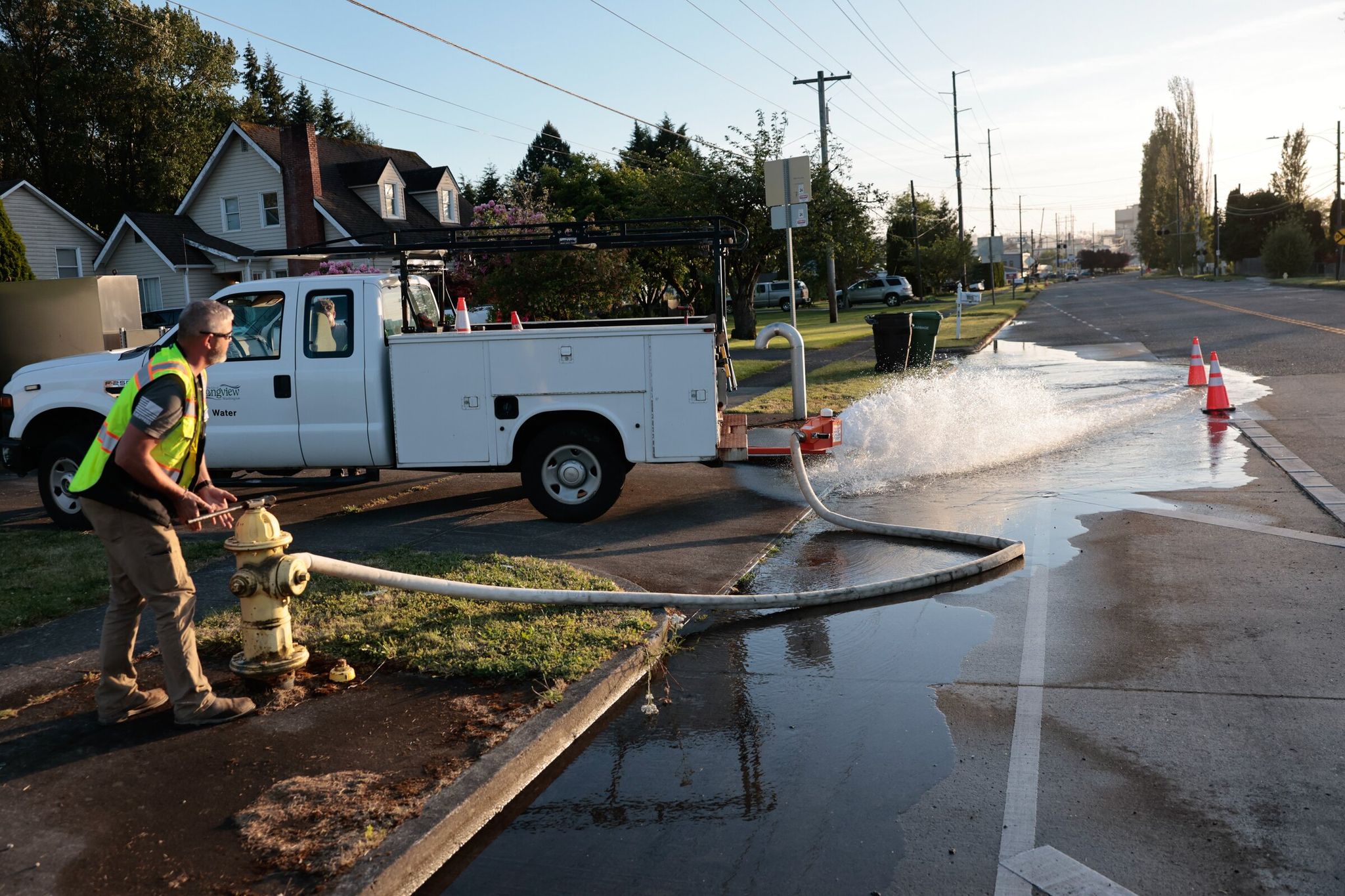 Crews from the city of Longview open fire hydrants and send water down the drains to dilute chemical runoff from the May 26 Nippon Dynawave implosion. (Karen Ducey / The Seattle Times)