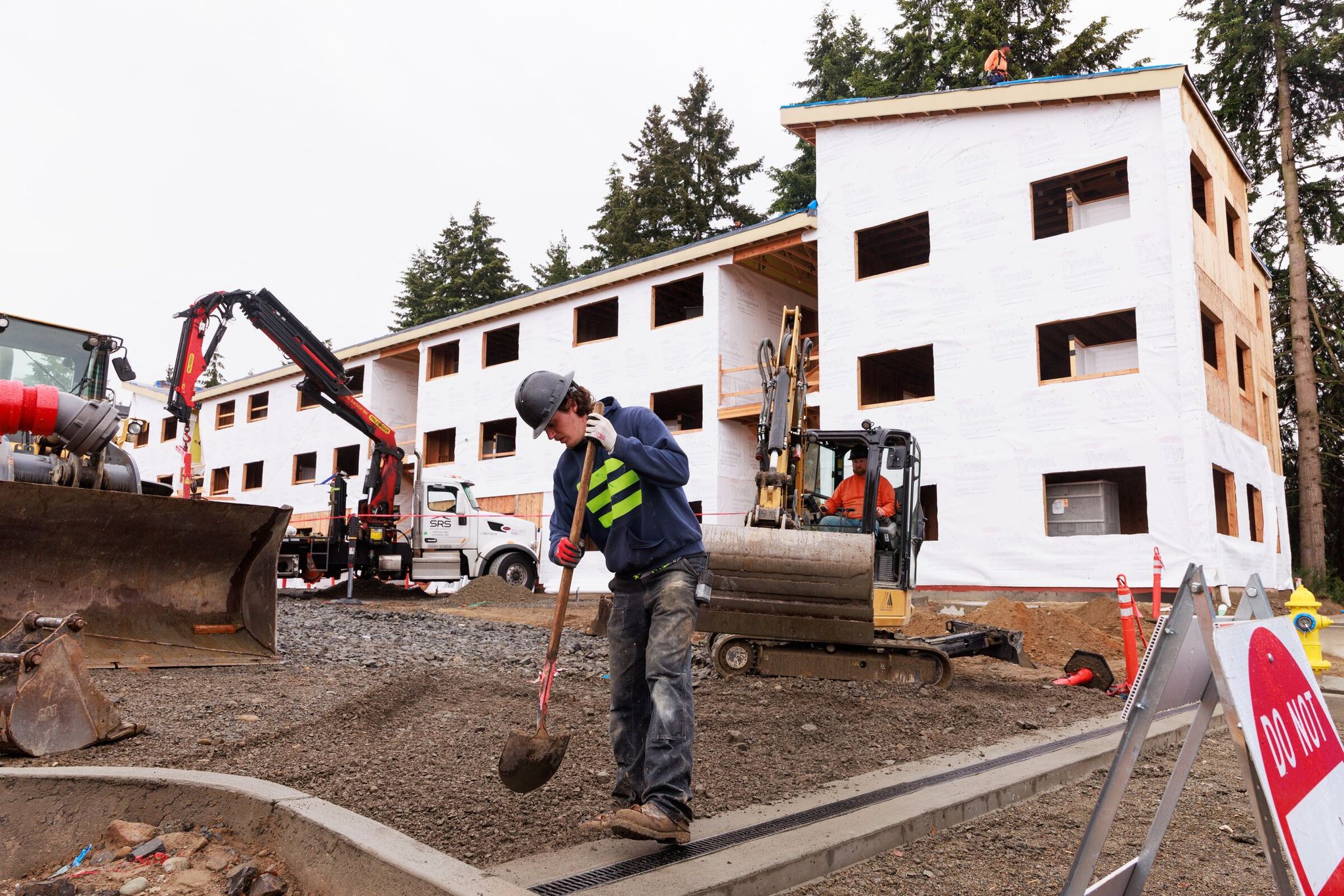 Construction workers including Colton Perry, foreground, build a 52-unit housing development in Lynnwood on Thursday for families of students who attend the Edmonds School District and qualify for federal assistance for homeless students. (Erika Schultz / The Seattle Times)