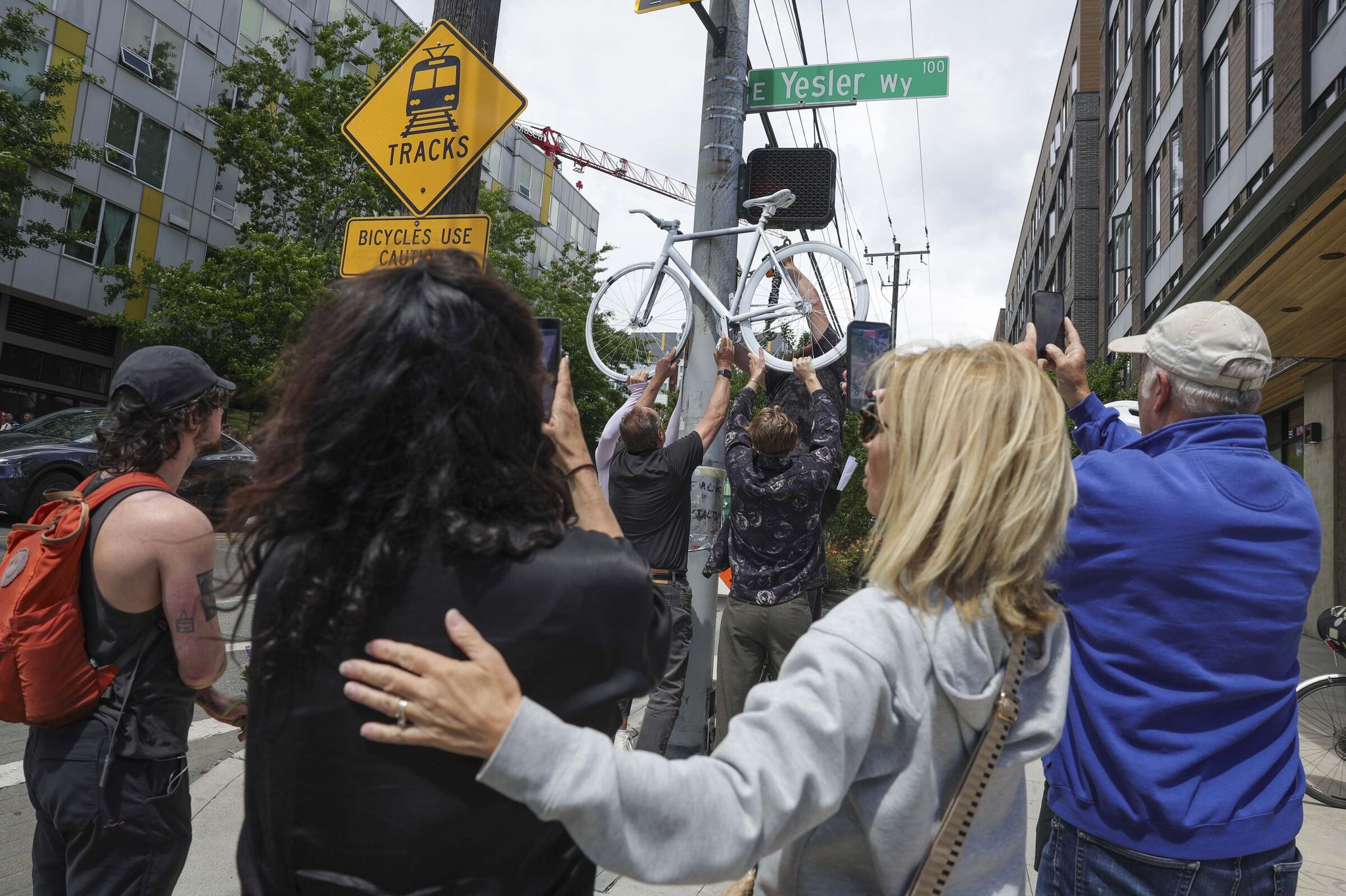 Loved ones and community members attend a ceremony Saturday at East Yesler Way and 12th Avenue South in Seattle in memory of Christian Salyer, 30, who died Monday after being struck by a truck. (Ivy Ceballo / The Seattle Times)