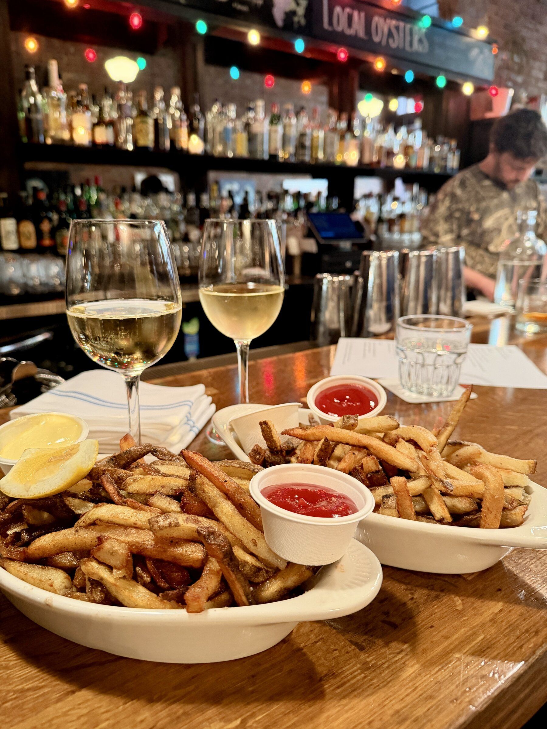 Two plates of frites are shown at Pioneer Square’s Damn the Weather, with the duck-fat frites at left and the regular frites on the right. (Margo Vansynghel / The Seattle Times)