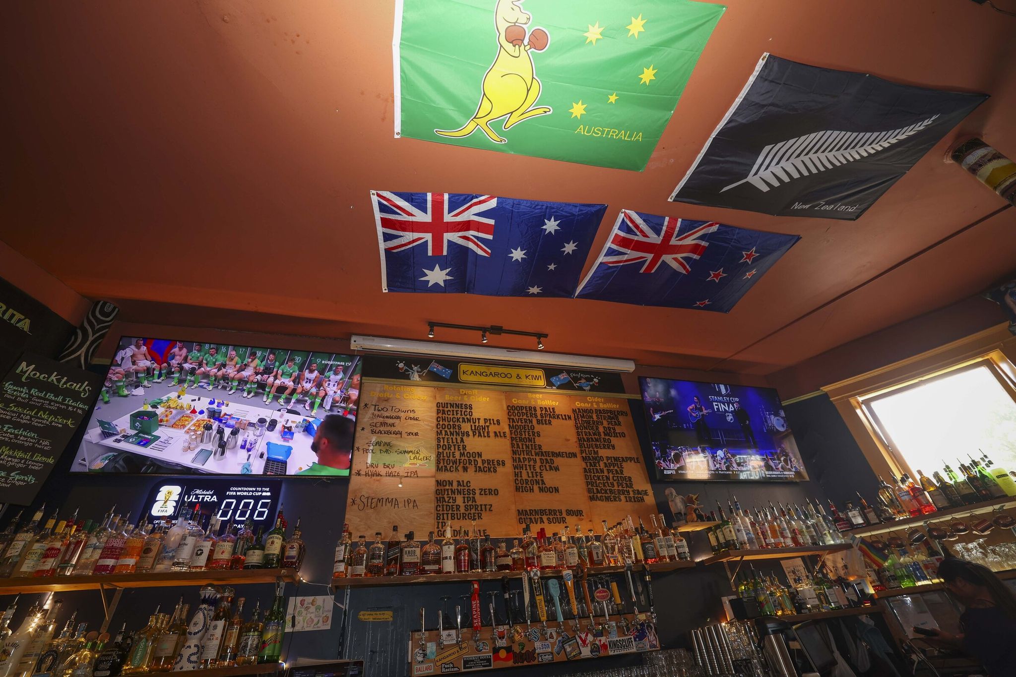 Sports flags are visible on the ceiling of Kangaroo & Kiwi on June 4. (Ivy Ceballo / The Seattle Times)