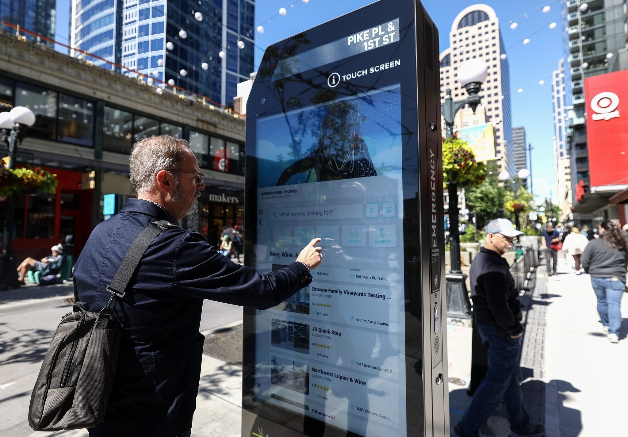 Ben Bakkenta explores a newly-installed IKE, or Interactive Kiosk Experience, near Pike Place Market on Tuesday, June 9, 2026, in Seattle. (Nick Wagner / The Seattle Times)