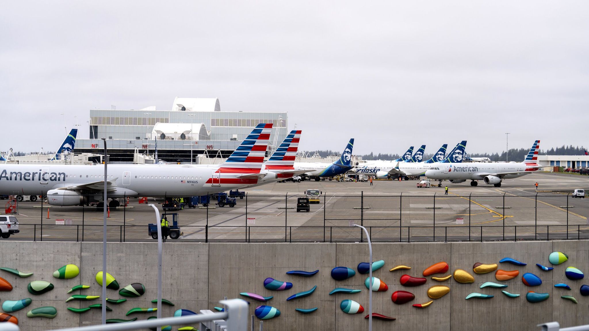 The “Migration” mural, a public art project commissioned for the Port of Seattle, lines the entrance to the departure terminal at Seattle-Tacoma International Airport in SeaTac.  (Brandon Garcia / The Seattle Times)