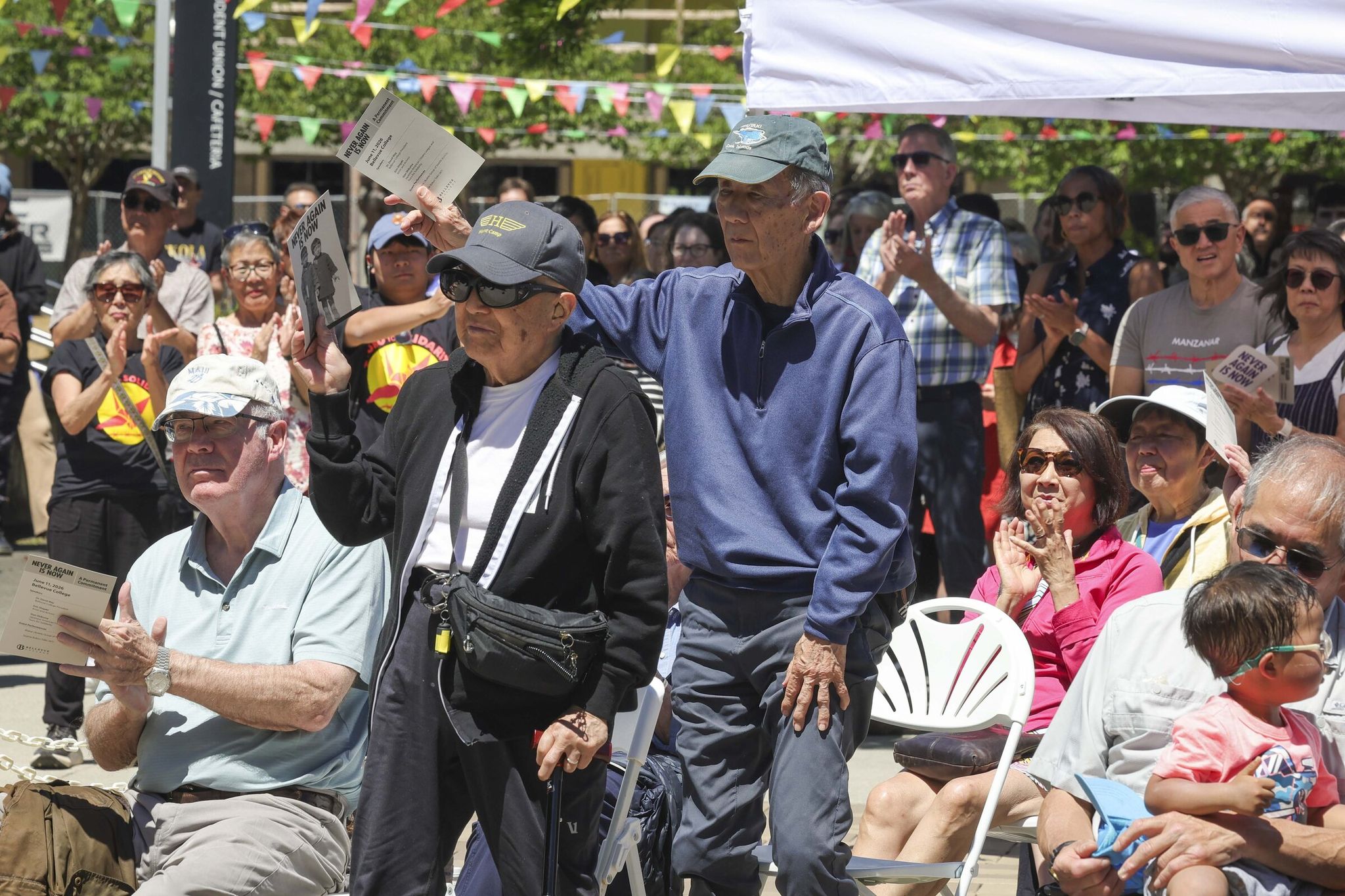 Japanese American survivors of mass incarceration during World War II stand during the dedication ceremony marking the permanent installation of Erin Shigaki’s mural 'Never Again Is Now' at Bellevue College in Bellevue on Thursday. (Ivy Ceballo / The Seattle Times)
