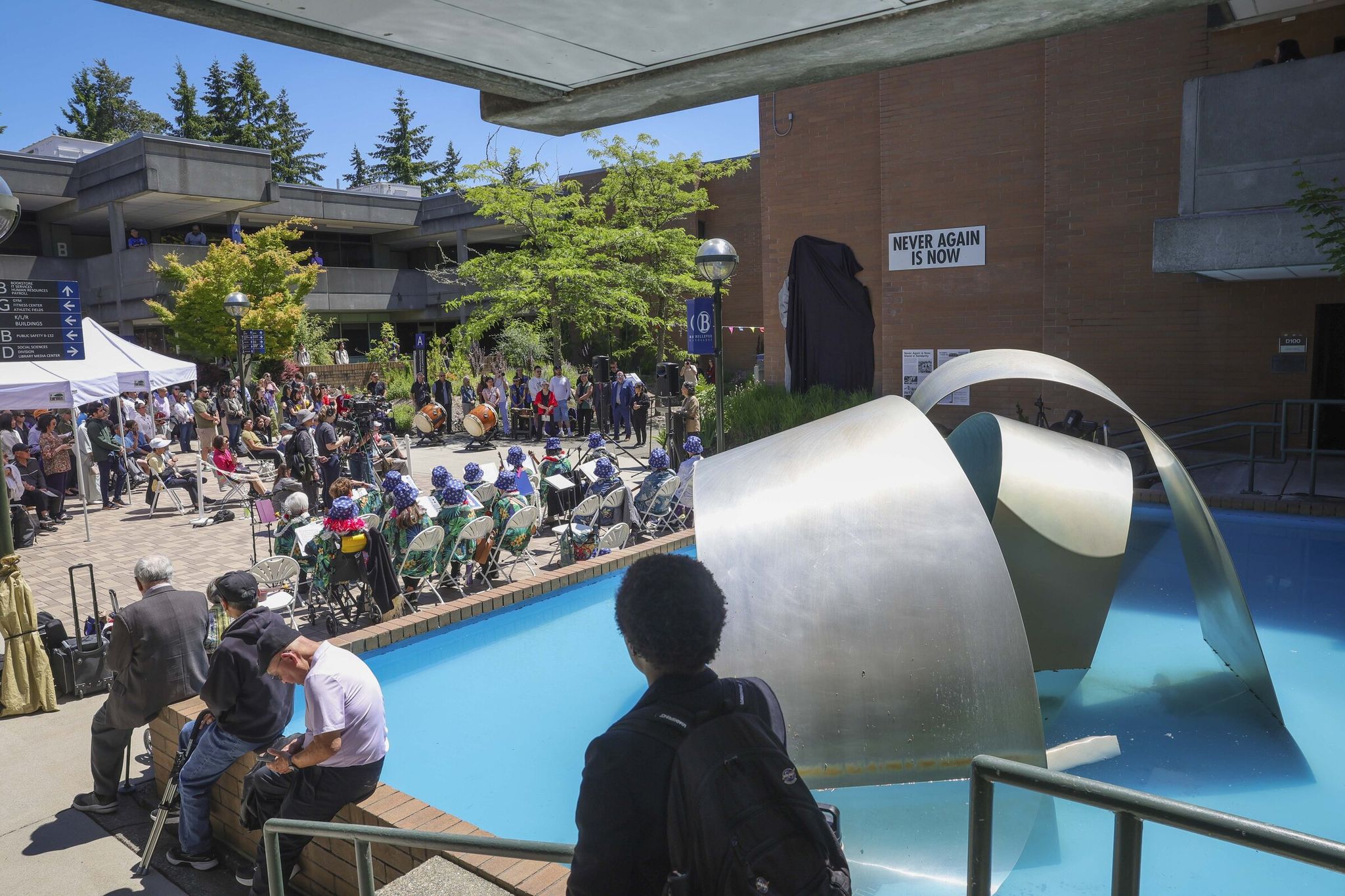 Artist and activist Erin Shigaki speaks at the dedication ceremony marking the permanent installation of her mural 'Never Again Is Now' at Bellevue College in Bellevue on Thursday. (Ivy Ceballo / The Seattle Times)