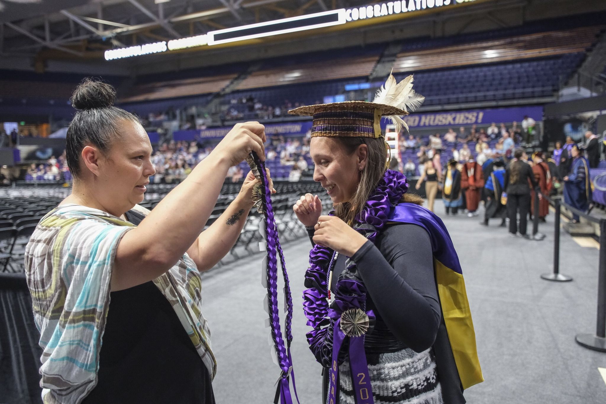 Rosalie Fish’s mother, Autumn, helps her adjust her gown before commencement ceremonies where Fish received her Master’s in Social Work degree from the University of Washington. (Dean Rutz / The Seattle Times)