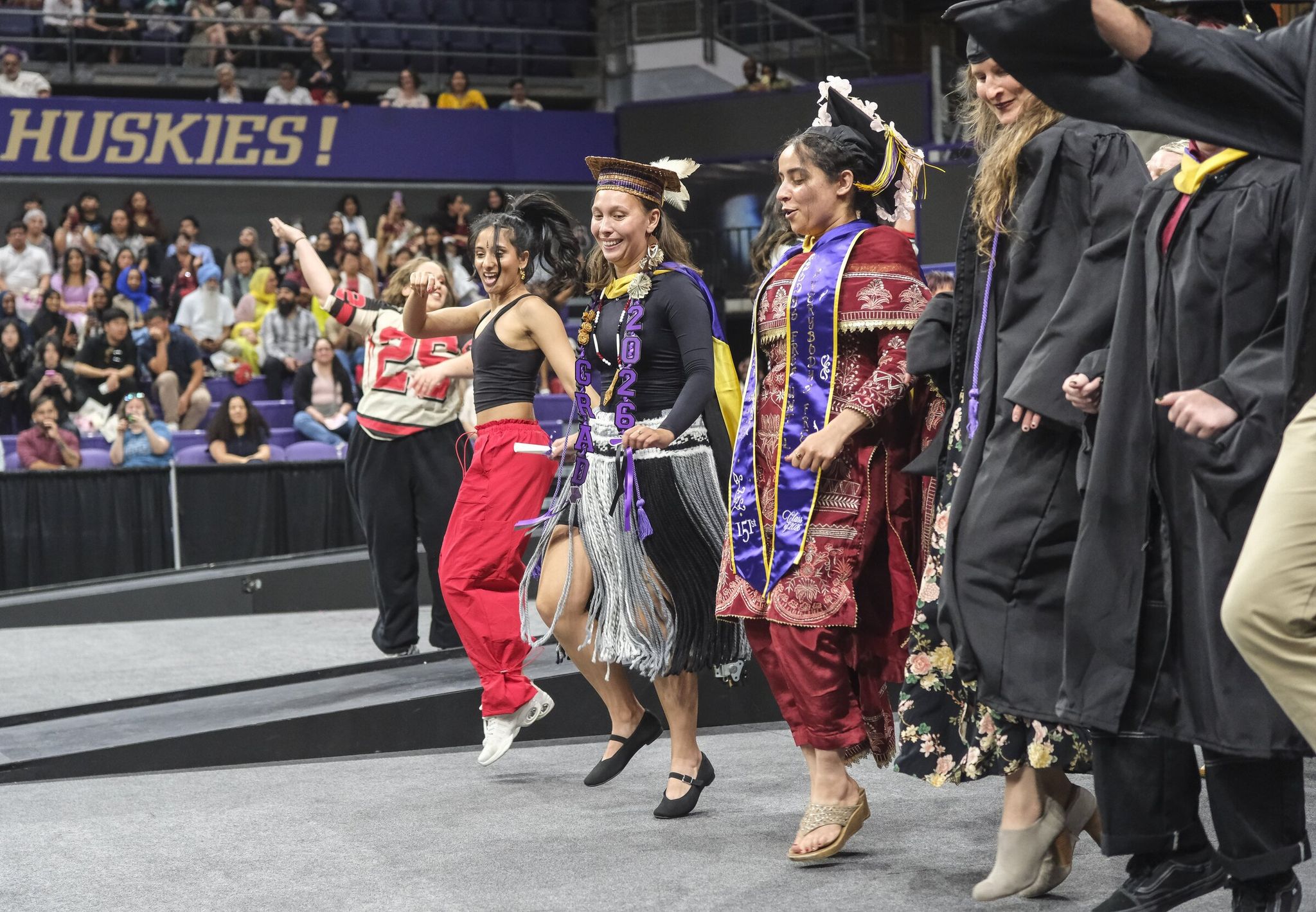 Rosalie Fish, front and center in black, joins a line dance performed by her and other graduates during ceremonies at the University of Washington. (Dean Rutz / The Seattle Times)