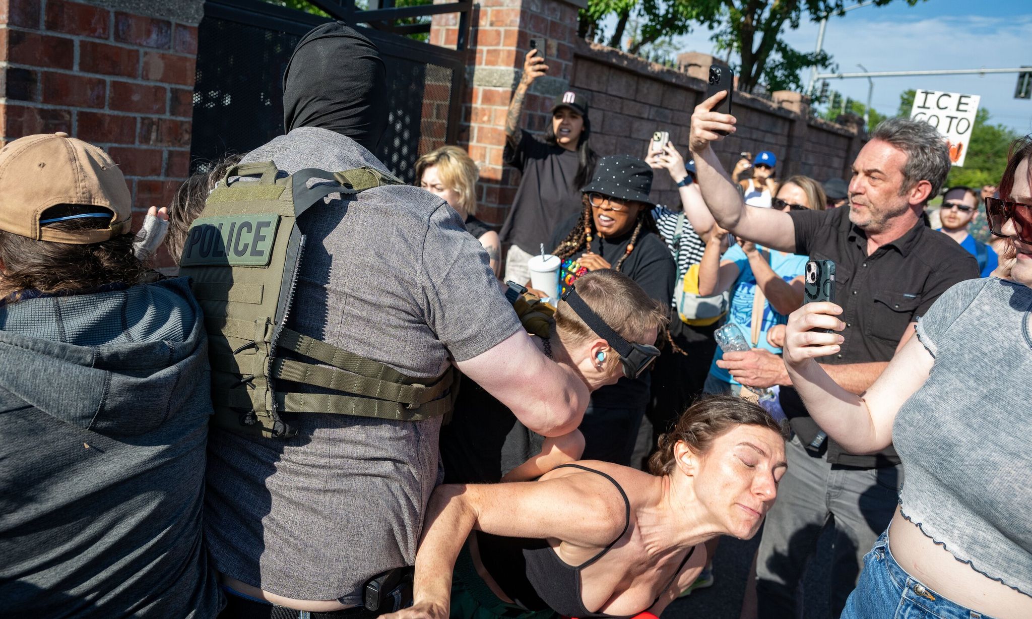 An ICE agent and protesters at the back gate of the ICE field office in downtown Spokane. (Colin Mulvany / The Spokesman-Review, 2025)