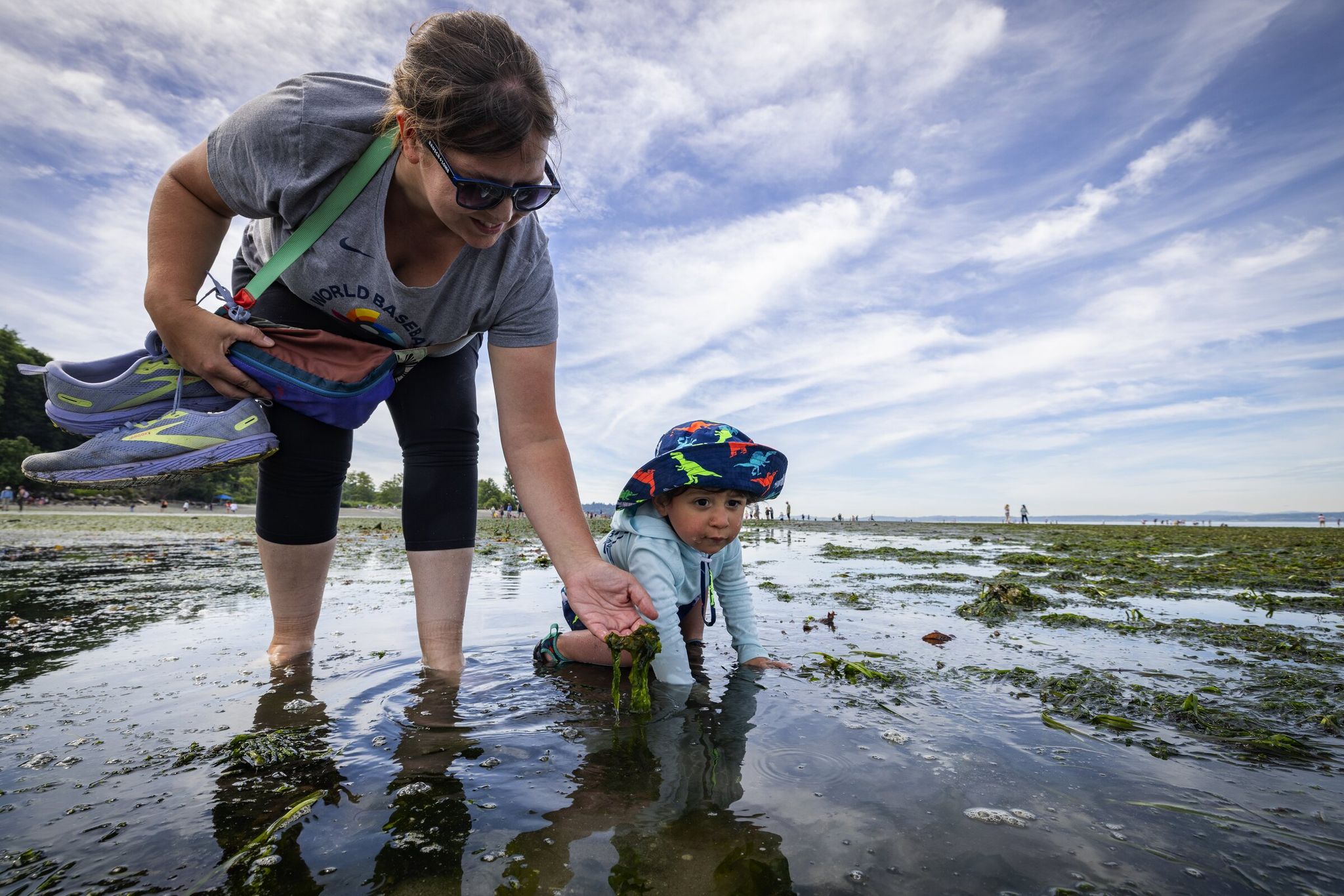 Hayley Raigosa and 23-month-old son Ronin experience low tide at Seattle’s Golden Gardens on Monday. The two are visiting from South Carolina. (Ken Lambert / The Seattle Times)