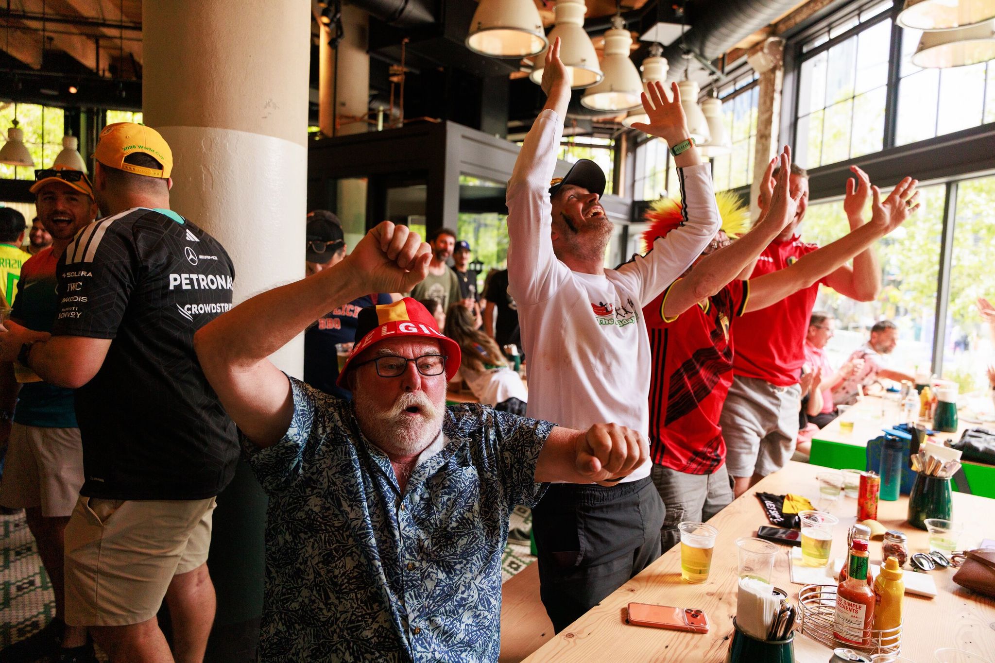 Fans at Lowlander Brewing — including Bob Domen, left, Mario Schmit, Kris Foubert and Jesse Buttler — celebrate a goal during the Belgium vs. Egypt World Cup in Seattle on Monday.  (Erika Schultz / The Seattle Times)