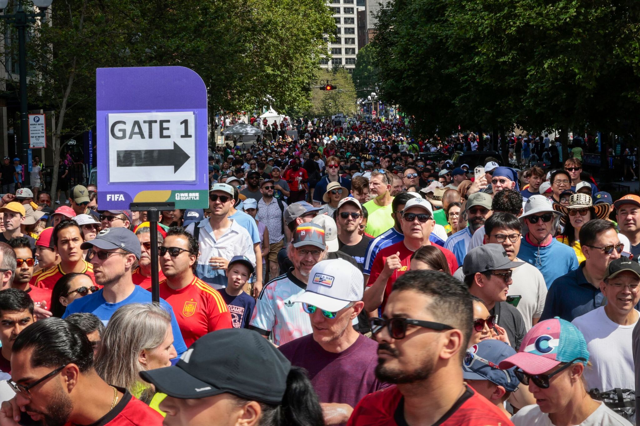 Fans head down Stadium Place South, on the north side of Seattle Stadium, to catch watch parties and festivities around the FIFA Men’s World Cup before Belgium vs. Egypt kicks off in Seattle on Monday. (Karen Ducey / The Seattle Times)