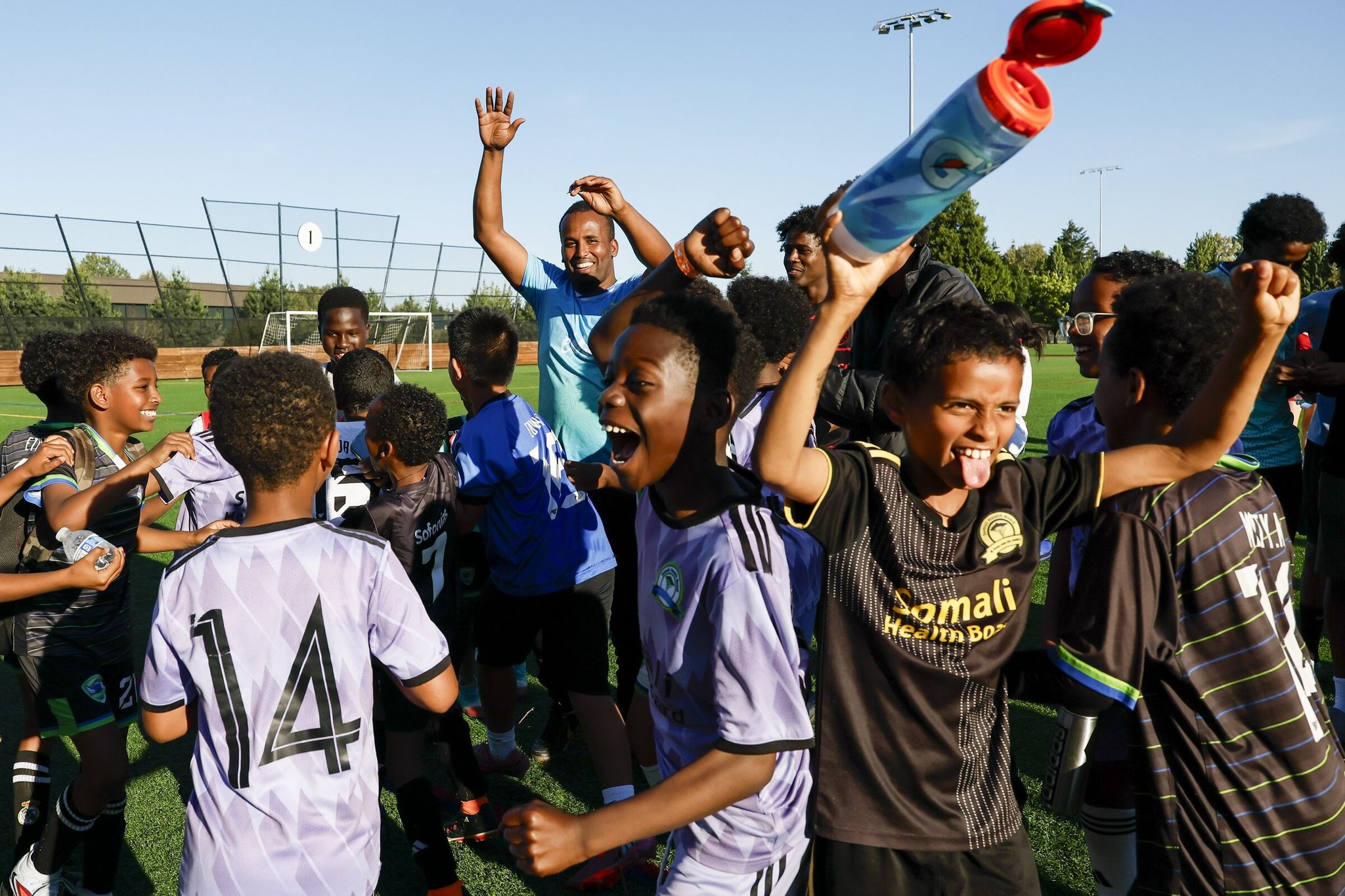One of the many teams participating in the Eid al-Adha 3 v 3 Soccer Tournament celebrates after finding out they won the raffle for World Cup tickets last Saturday. Four teams won the raffle with one player each of the four winning a pair of World Cup tickets.  (Jennifer Buchanan / The Seattle Times)