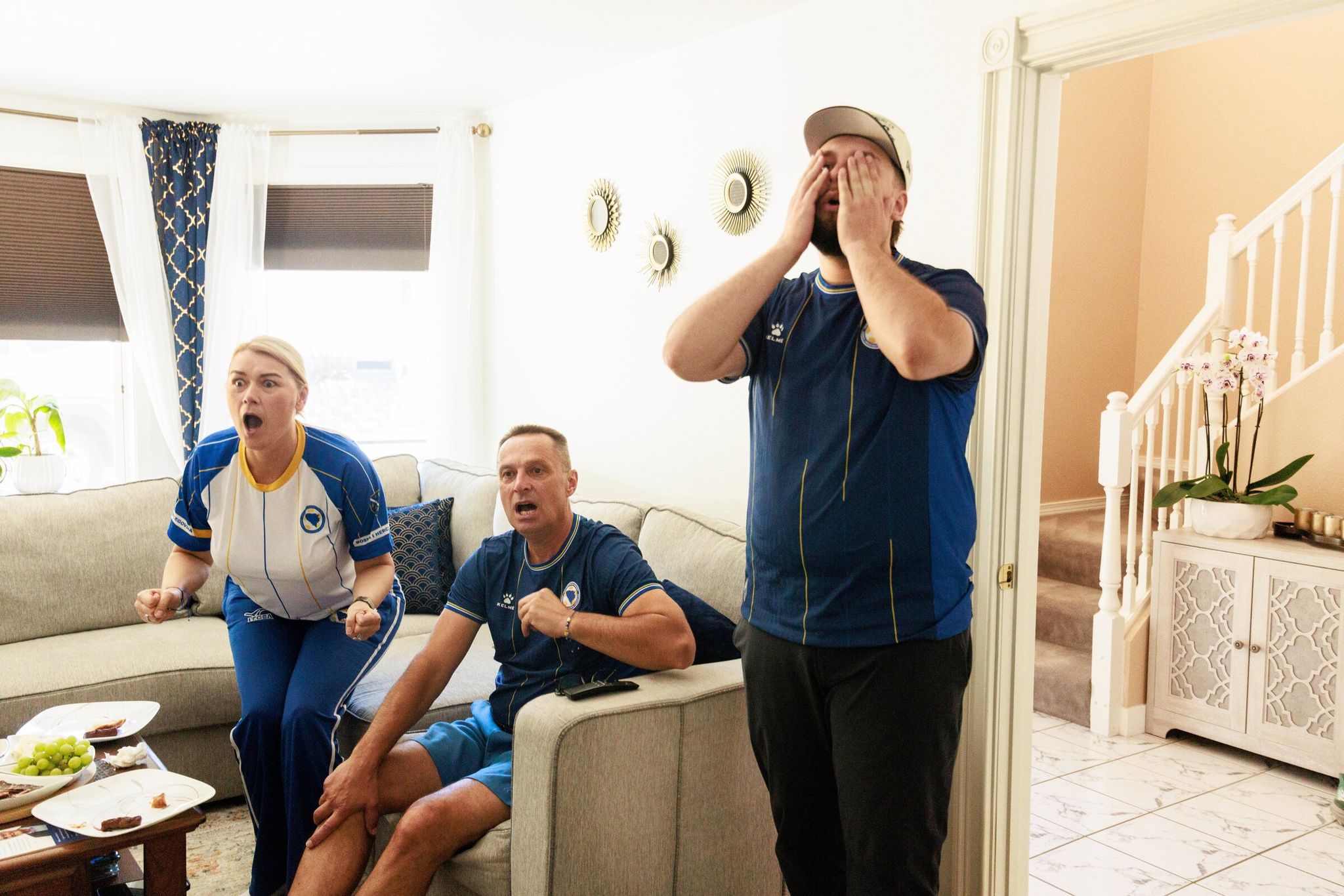 Elvira Vojinovich, left, her husband Amir Vojinovich, and son Benjamin Vojinovich watch the World Cup match between Switzerland and Bosnia and Herzegovina at home in Shoreline. (Erika Schulz / The Seattle Times)