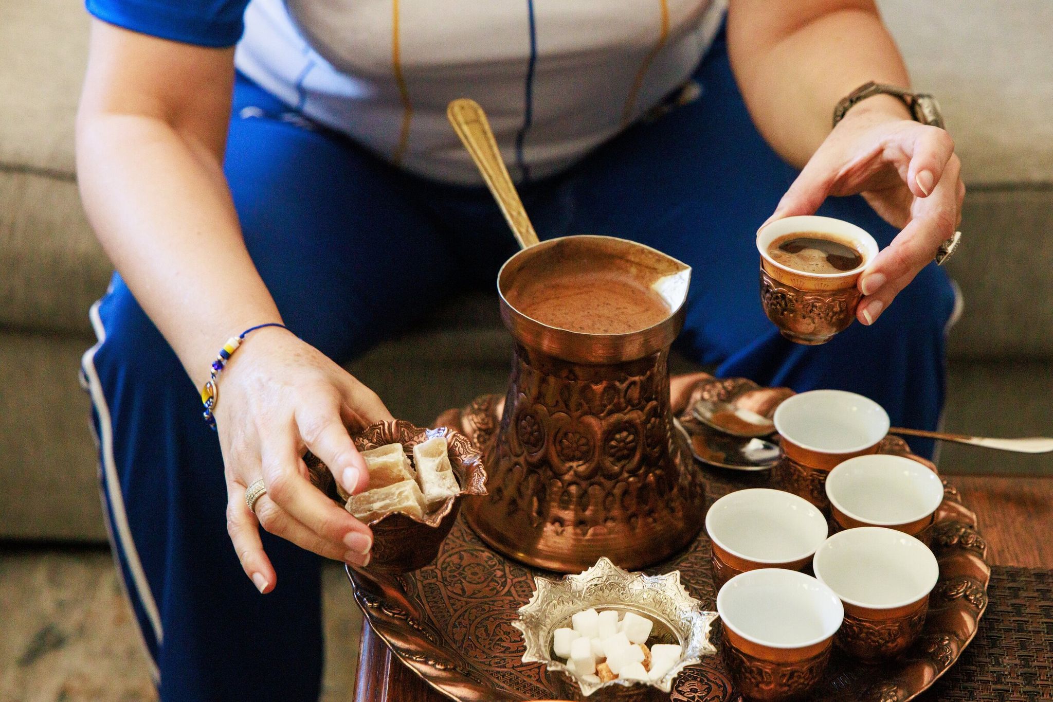 Elvira Vojinovich pours Bosnian coffee, similar to Turkish coffee, from a džezva during the World Cup match between Switzerland and Bosnia and Herzegovina at home in Shoreline. (Erika Schulz / The Seattle Times)