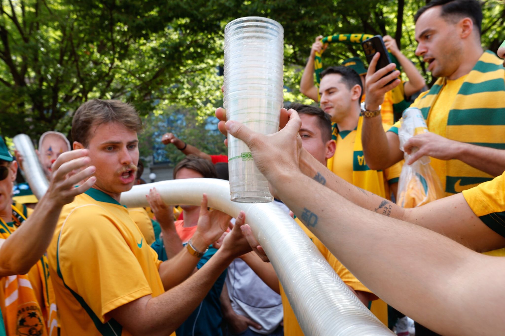 At Victory Hall in SoDo, Australian soccer fans create a beer “snake” out of plastic cups as they celebrate “Socceroos” victory ahead of the Australia vs. United States match in Seattle on June 19. (Karen Dusi / The Seattle Times)