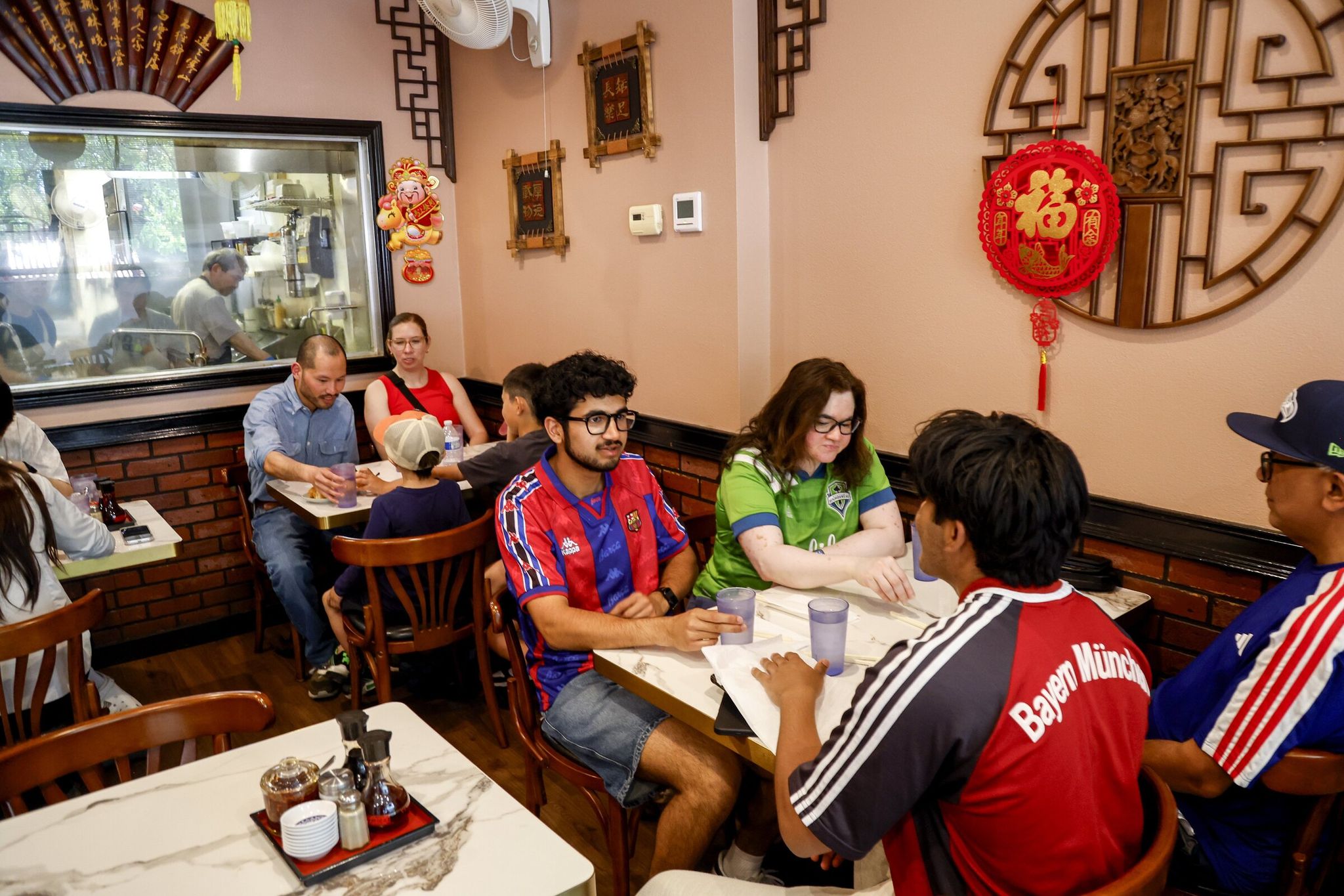After the World Cup match, Arjun Singh of Kenmore, Washington (center), and his family dine at Mike’s Noodle House in Seattle’s Chinatown-International District on Wednesday, June 24, 2026, after the Bosnia and Herzegovina vs. Qatar match at the World Cup. (Andrew Burke-Stevenson / The Seattle Times)