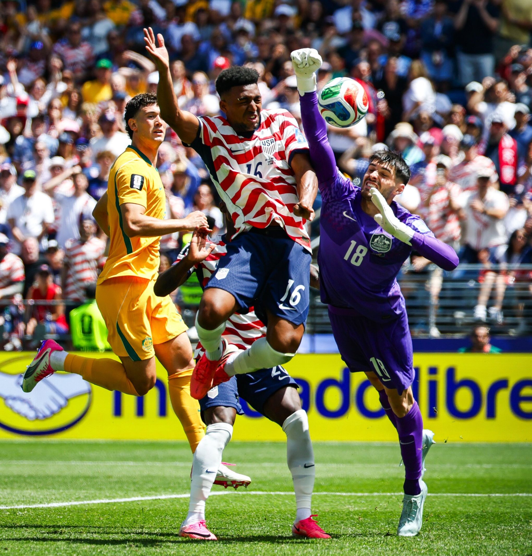 U.S. defender Alex Freeman heads in the second goal in a match against Australia goalkeeper Patrick Bich. (Jennifer Buchanan / The Seattle Times)