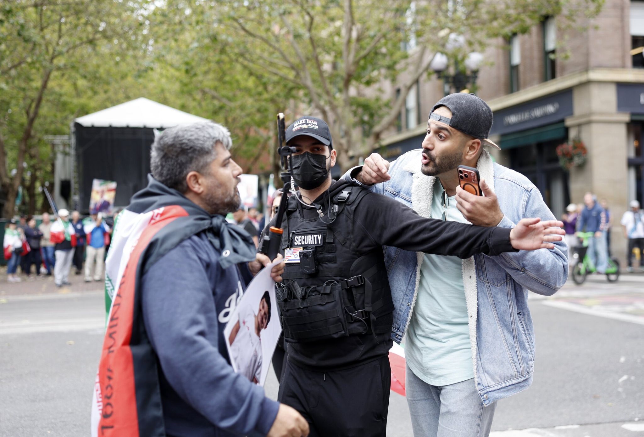 Kea Moradi of Seattle, on the right, protests against the Islamic Republic regime and argues with a man carrying the current national flag of Iran outside Seattle Stadium in Pioneer Square before the World Cup group stage match between Egypt and Iran in Seattle. (Karen Dusi / The Seattle Times)