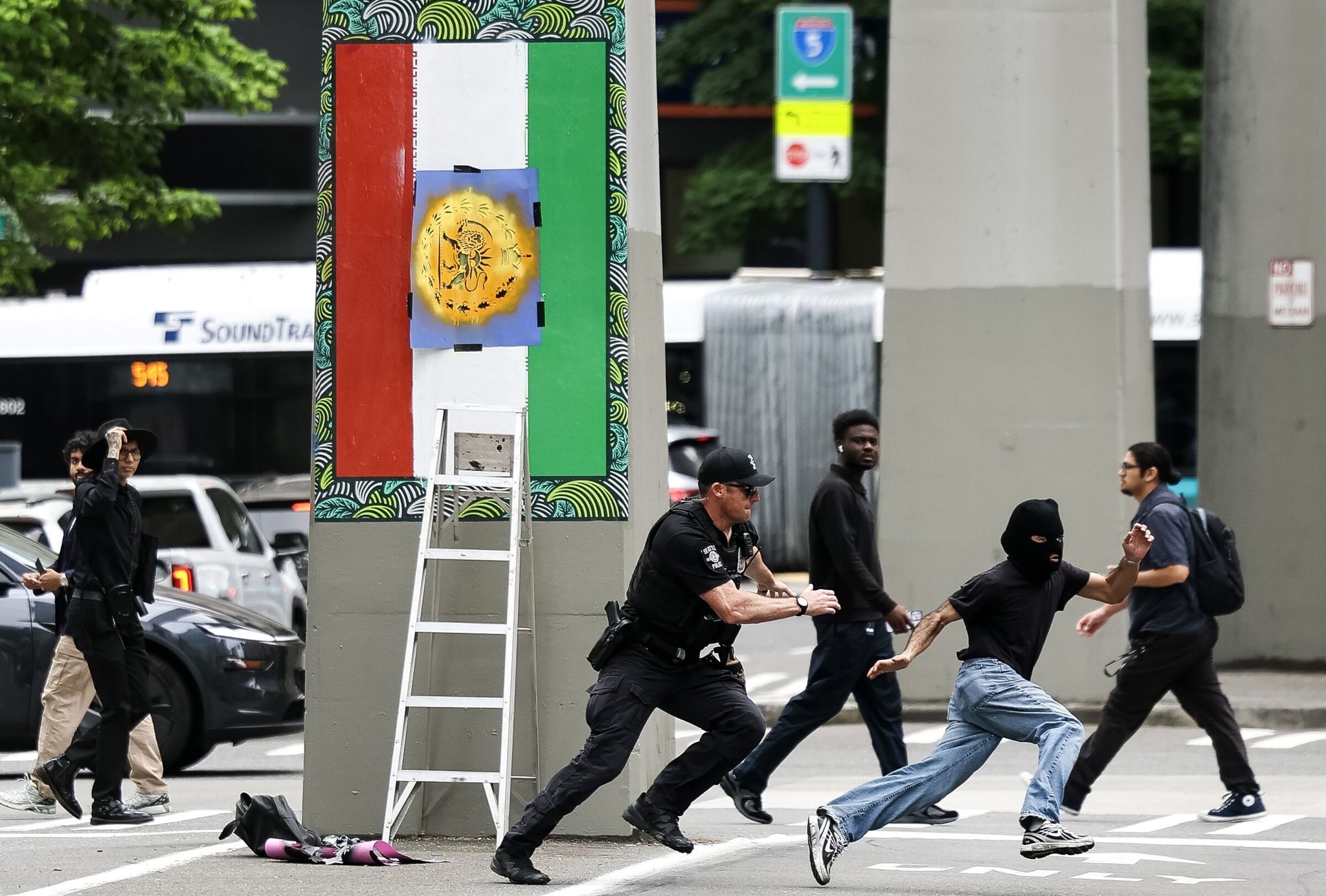 On Thursday in downtown Seattle, on Fifth Avenue under the monorail columns, a masked man was caught painting over an Iranian flag image installed earlier this month in honor of the World Cup. The incident occurred the day before Iran’s national team played Egypt in the World Cup group stage at Seattle Stadium. (Nick Wagner / The Seattle Times)