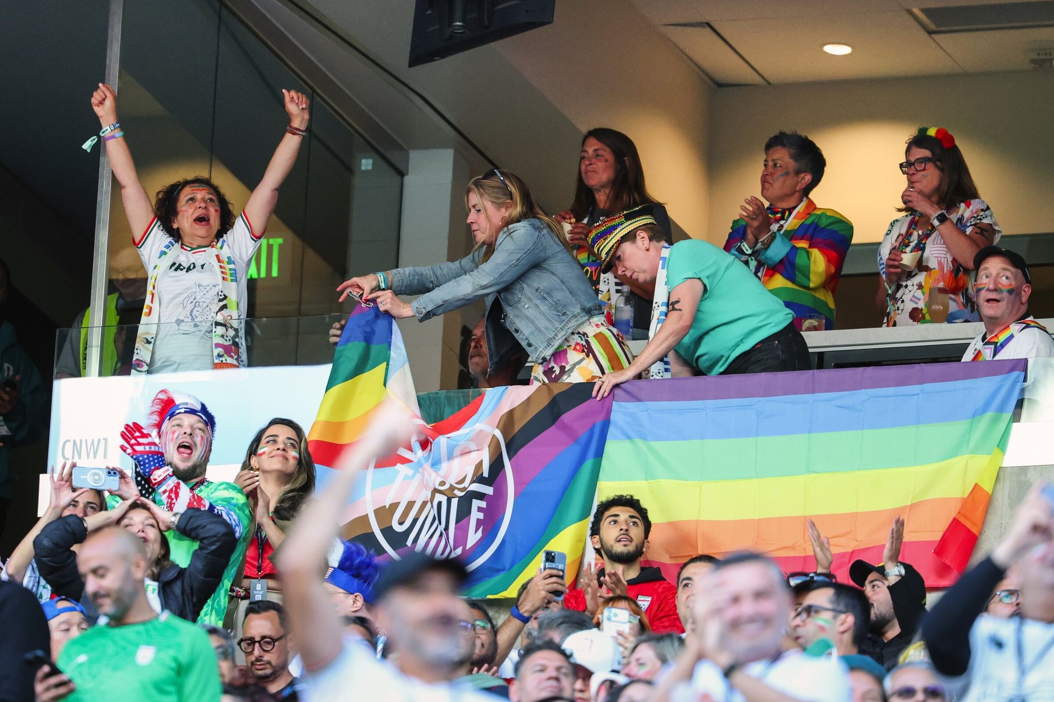 Jen Barnes (center) wearing a rainbow hat, founder of the Rough and Tumble pub, and friends decorating a room with Pride flags ahead of the FIFA World Cup League match “Pride Match” Iran vs Egypt on Friday, June 26, at Seattle Stadium. (Dean Rutz / The Seattle Times)