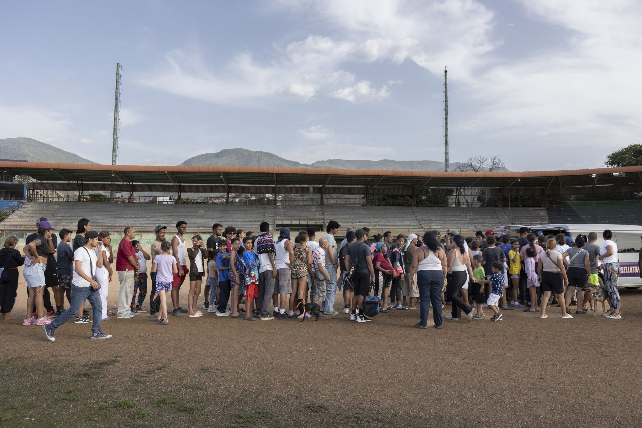 People lined up on Thursday to receive hygiene supplies at a baseball stadium after Wednesday’s earthquakes in La Guaira, Venezuela. Rescue crews and residents dug through rubble on Thursday night in search of survivors&mdash;growing more desperate by the hour. (Fabiola Ferrero / The New York Times)
