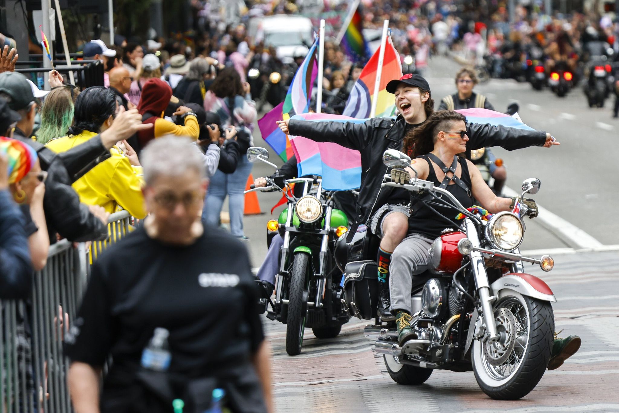 A passenger cheers while sitting on the back of one of the motorcycles as “Dykes on Bikes” launches the annual Pride parade in downtown Seattle on Sunday. (Andrew Burke-Stevenson / The Seattle Times)