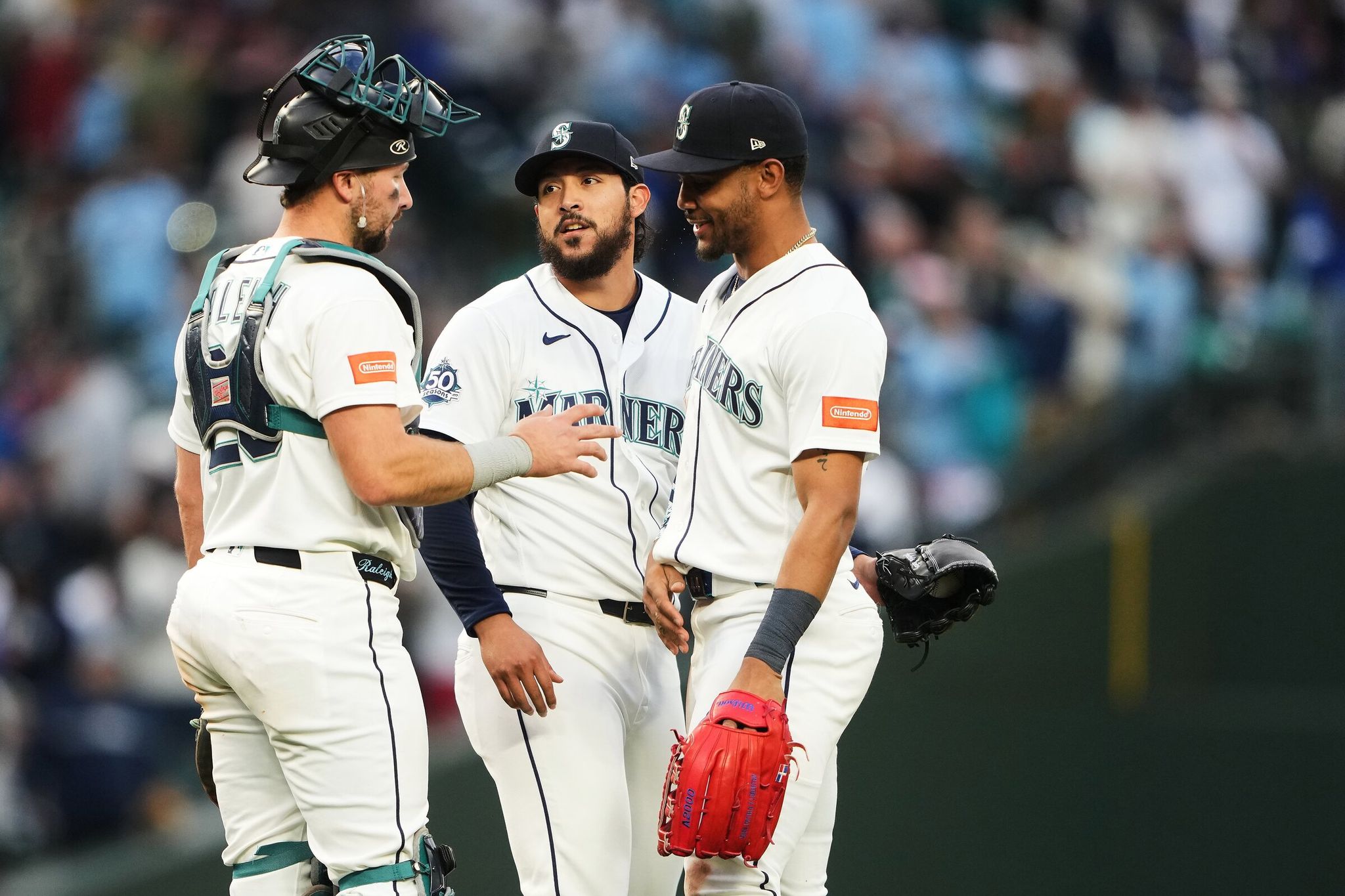 Seattle Mariners catcher Cal Raleigh, left, greets relief pitcher Andrés Muñoz, center, and center fielder Julio Rodríguez, right, as they celebrate a win over the Texas Rangers in a baseball game, Saturday, April 18, 2026, in Seattle. (Lindsey Wasson / AP)