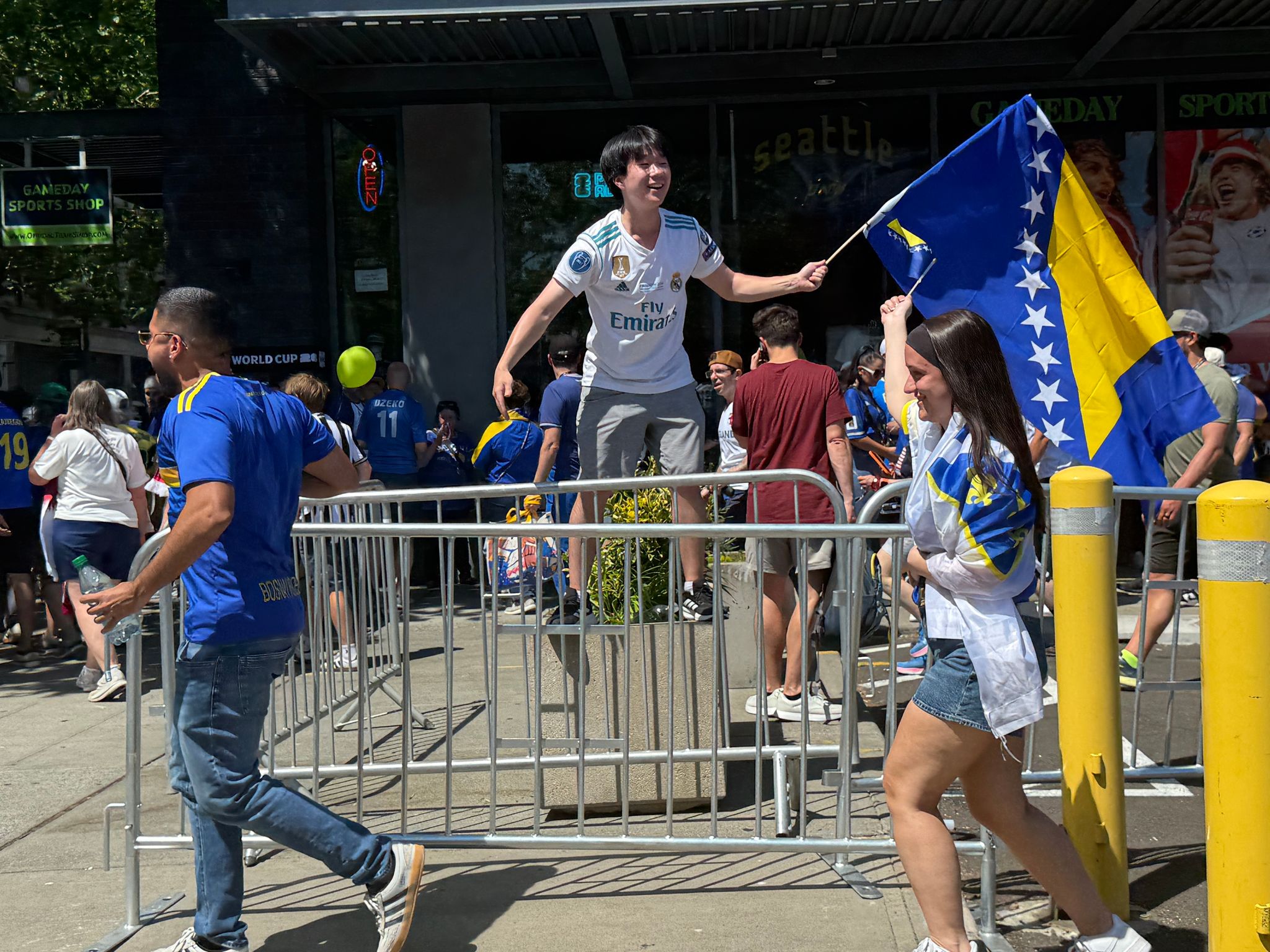Regan Kim of Lynnwood waves a flag for Bosnia after the match on Wednesday outside Seattle Stadium. (Olivia Petty / The Seattle Times)