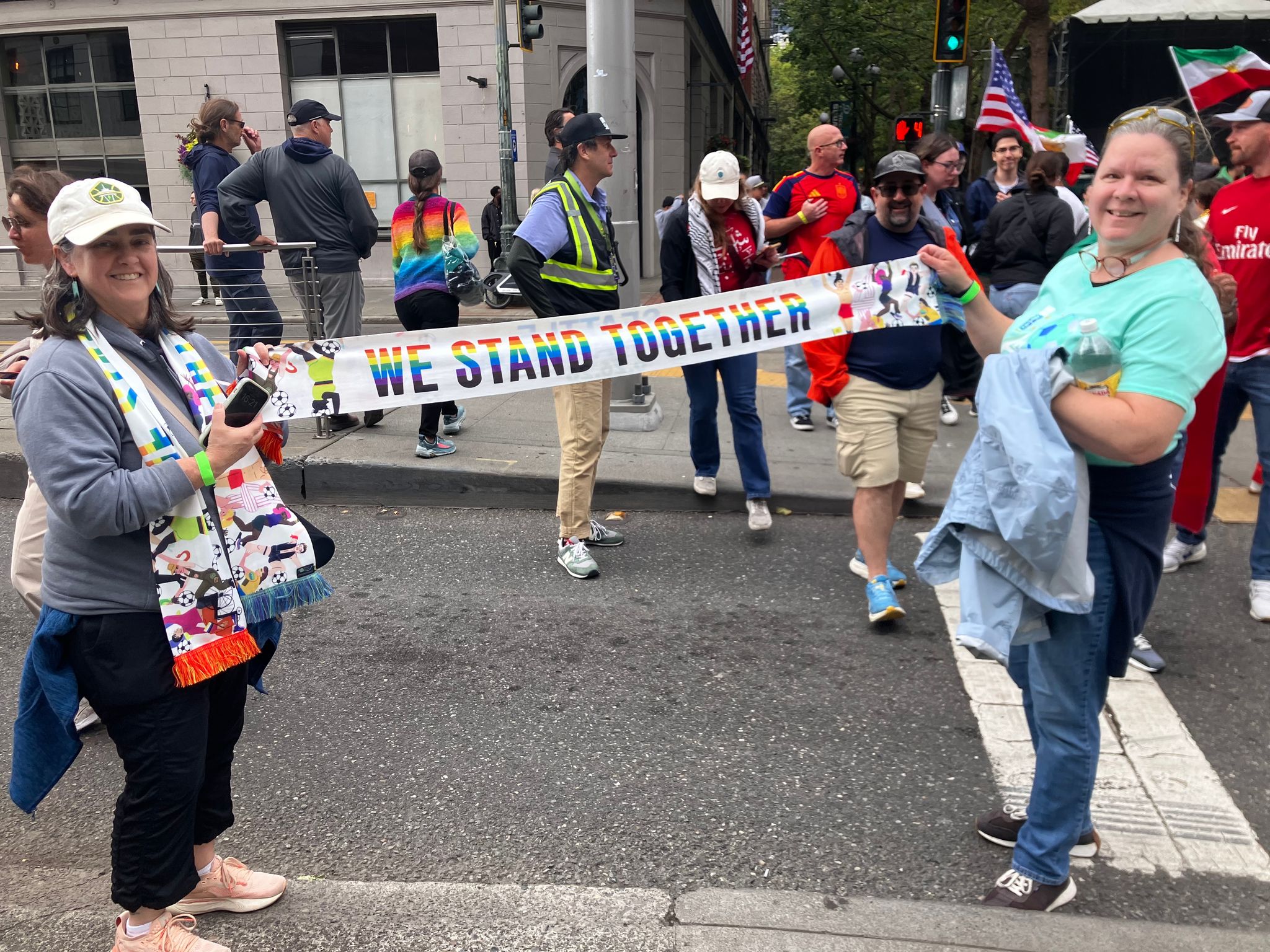 Shurya Jessika and Lori Werner, right, hold bright Pride Match Day scarves near Seattle Stadium before the World Cup match on Friday. (Elsk Yoon-Hendricks / The Seattle Times)