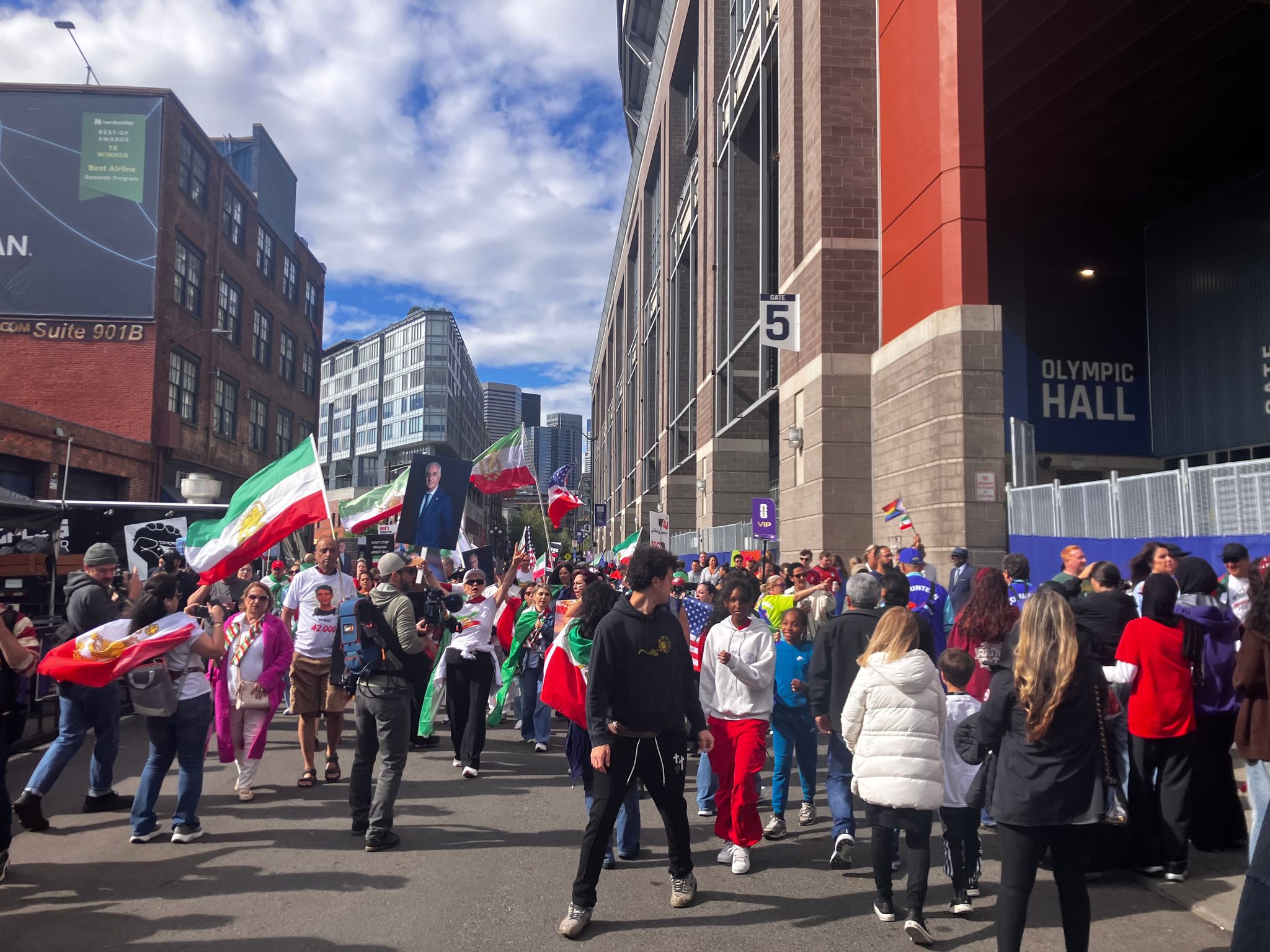 Protesters brush shoulders with fans trying to enter Seattle Stadium before the World Cup match on Friday. (Alex Yoon-Hendricks / The Seattle Times)