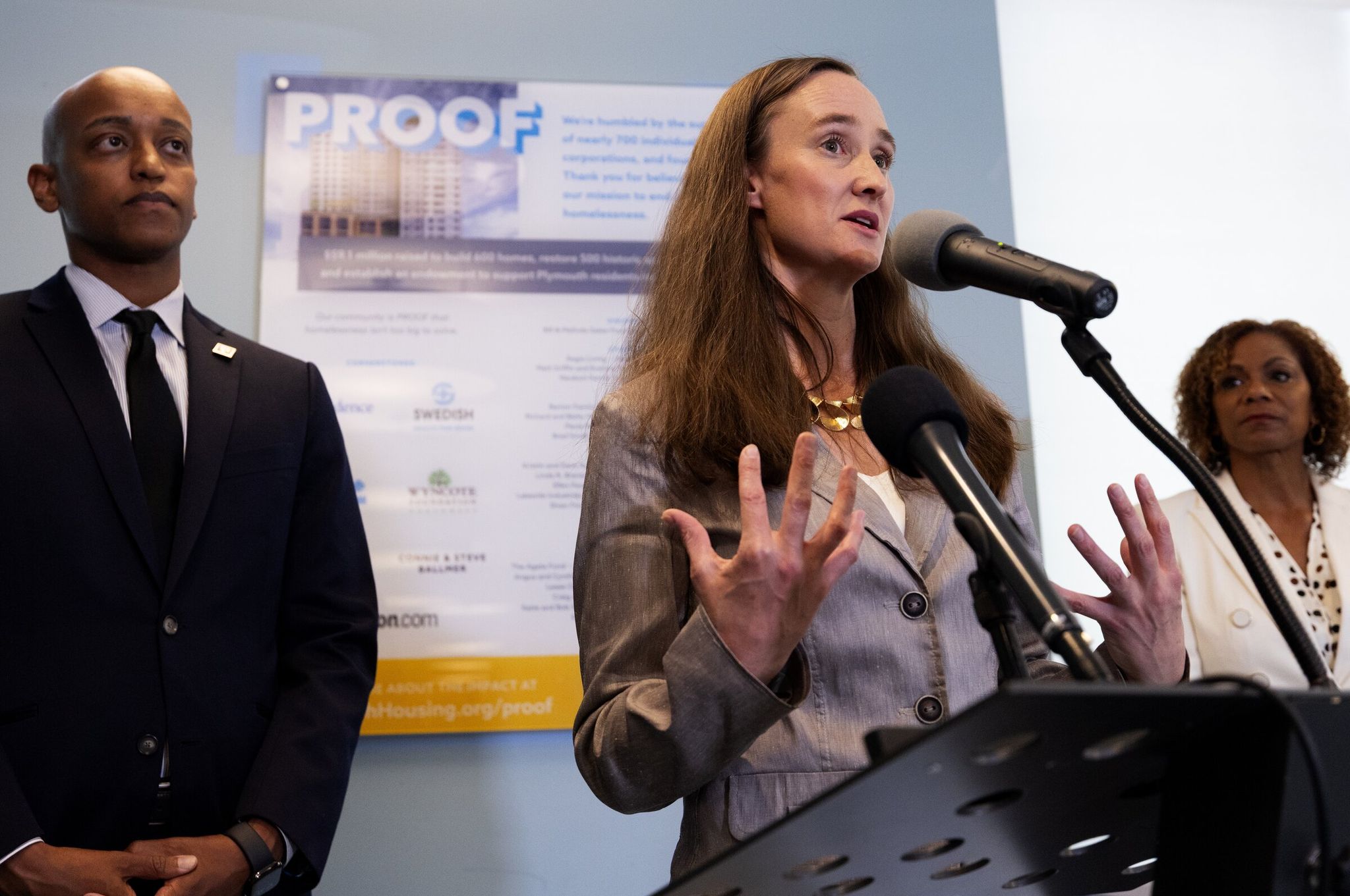 Seattle mayor Katie Wilson, center, responds to a reporter’s question at a press conference announcing changes to the King County Regional Homelessness Authority, Wednesday, July 1, 2026, in Seattle. Looking on are Girmay Zahilay, King County Executive and Karen Lee, CEO of Plymouth Housing. (Ken Lambert / The Seattle Times)