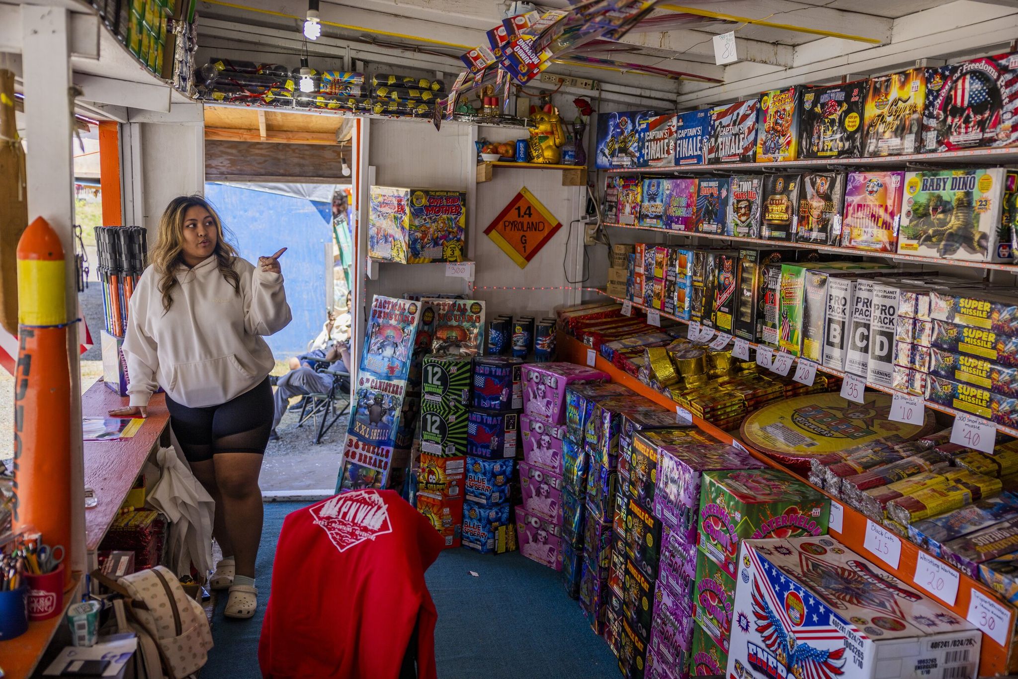 Lala Meach-Cross, 25, describes different kinds of fireworks before making a sale at the fireworks mall at the Muckleshoot Reservation in June 2022. (Daniel Kim / The Seattle Times)