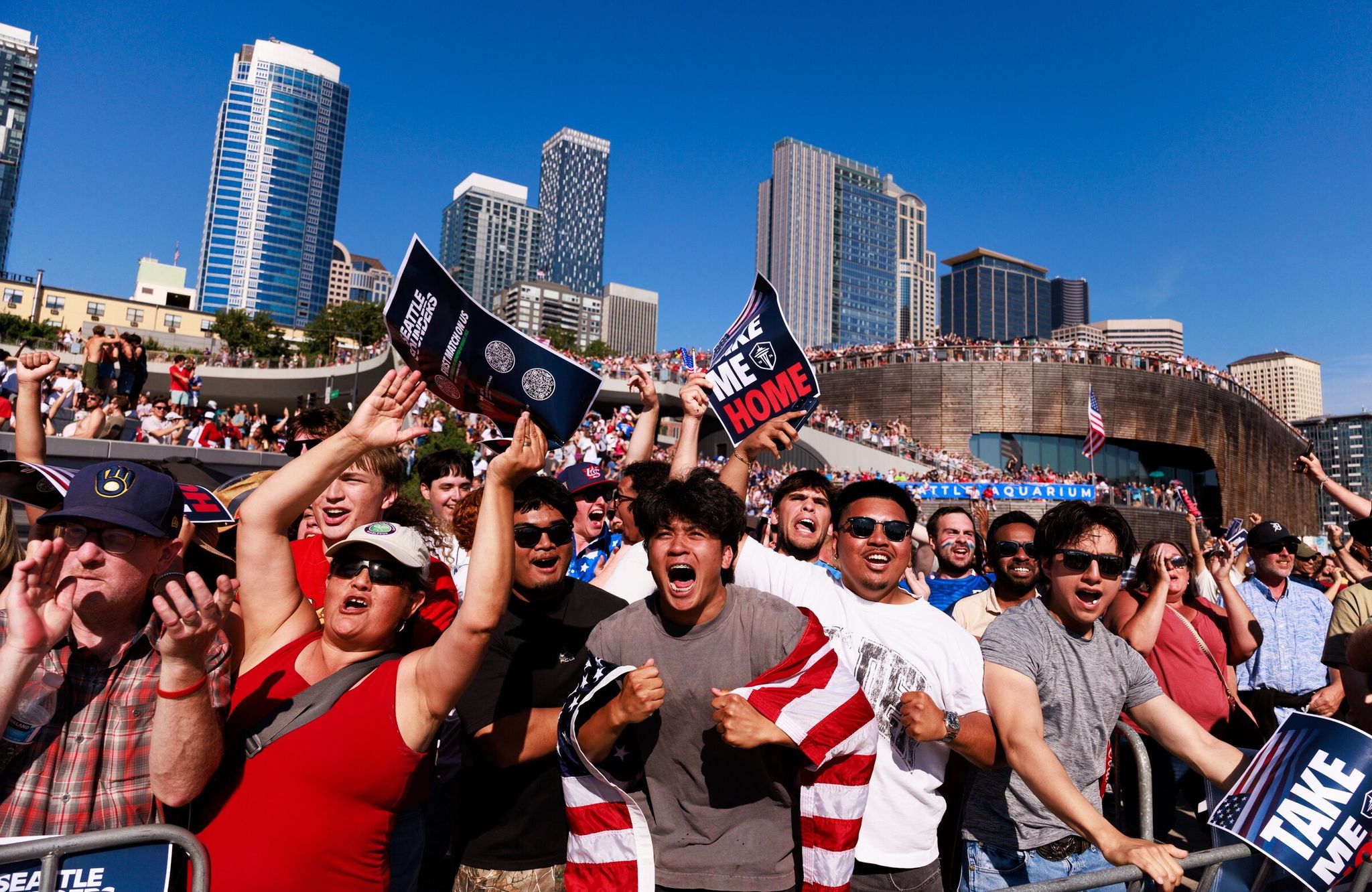 Lawrence Muhat, with American flag, and Jazz Antonino, white shirt and sunglasses, celebrate the United States’ first goal during a World Cup round of 16 soccer match between the United States and Belgium in Seattle. (Erika Schultz / The Seattle Times)