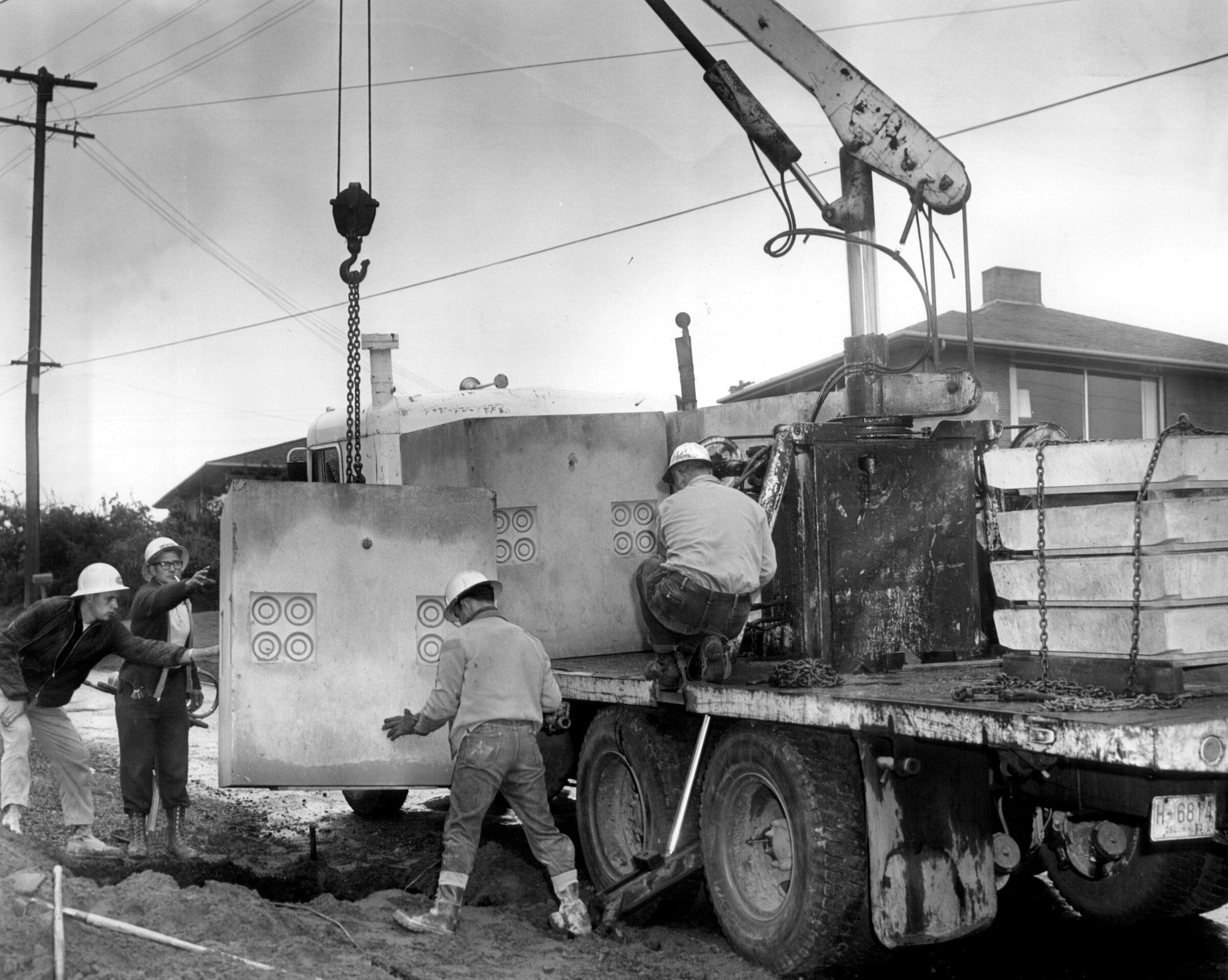 A transformer container is lowered into the ground in a West Seattle neighborhood in August 1965. (Seattle Times archive)