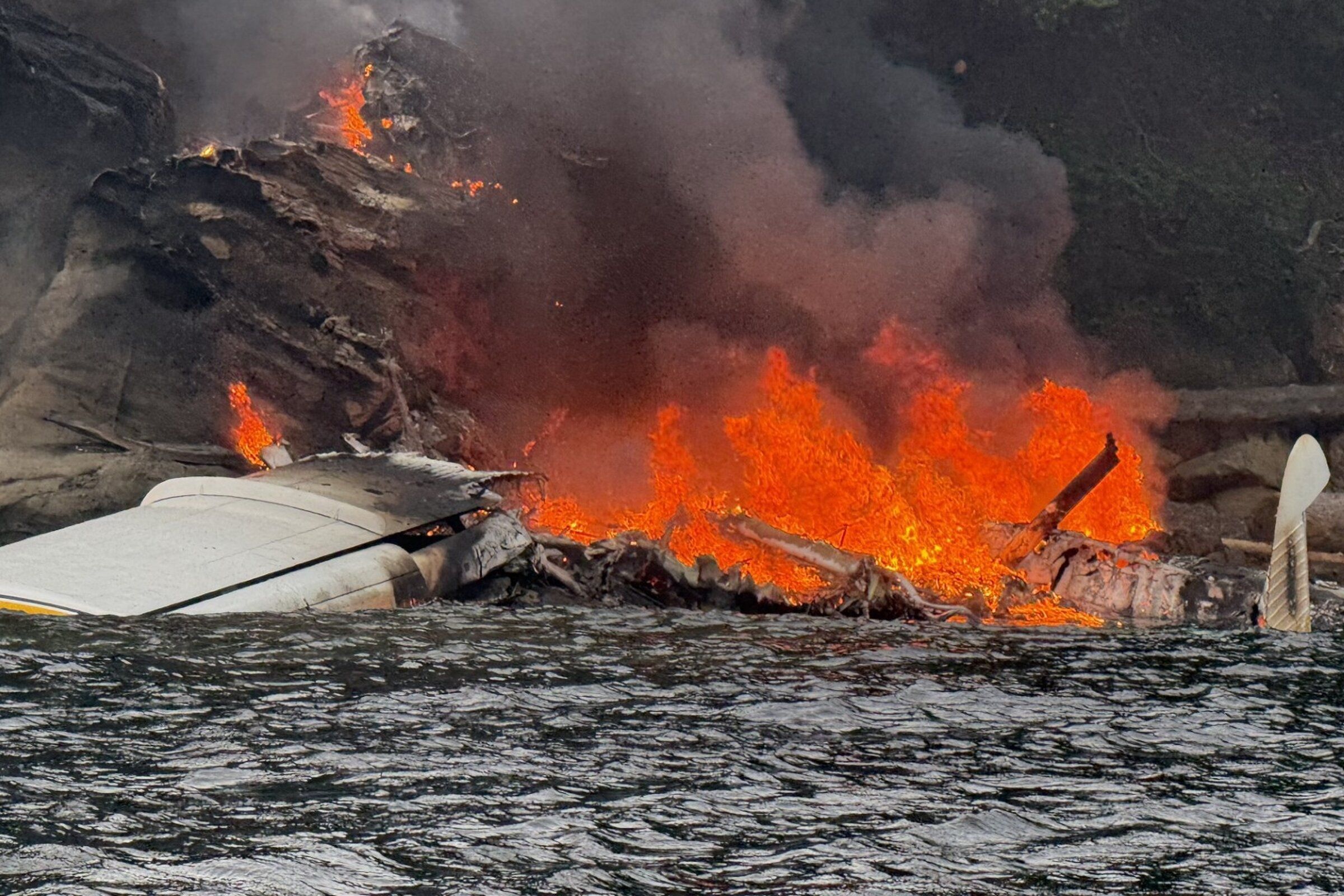A Kenmore seaplane burns after crashing on the shore near Sucia Island on Thursday, July 23, 2026, in the San Juan Islands. (Dave Estman via AP)