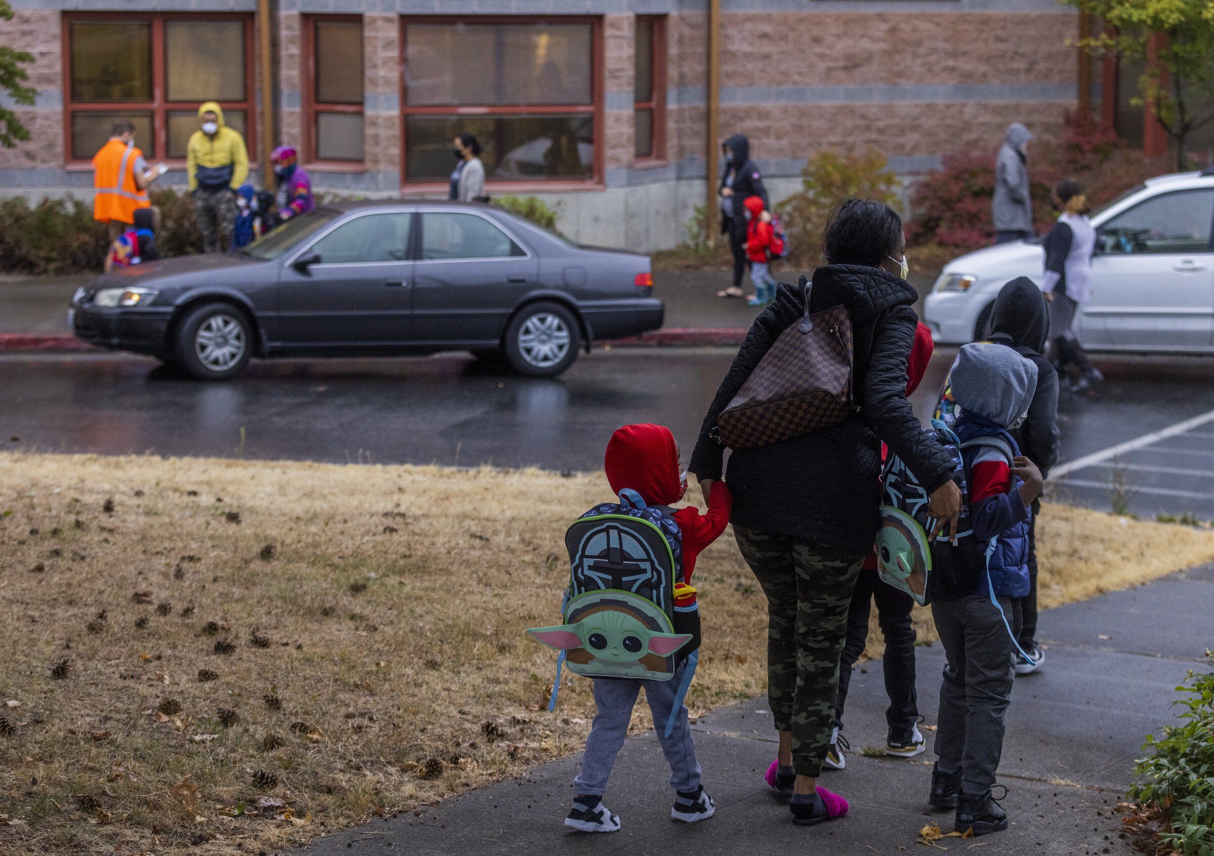 A group of students are dropped off at Rising Star Elementary School. More than a month after a Seattle Public Schools investigation determined that a special-education teacher — and recently elected president of the local teachers union —  at the elementary school “more likely than not” grabbed a student’s arm hard enough to cause bruising, the educator is responding to the allegations publicly, for the first time.  (Daniel Kim / The Seattle Times, 2021)