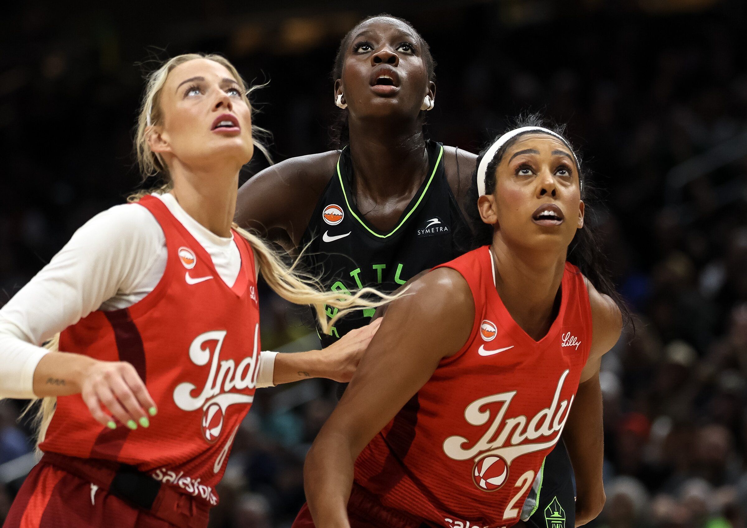 Storm center Awa Fam eyes a shot while being defended by Fever guard Sophie Cunningham, left, and forward Monique Billings on Tuesday. (Nick Wagner / The Seattle Times)