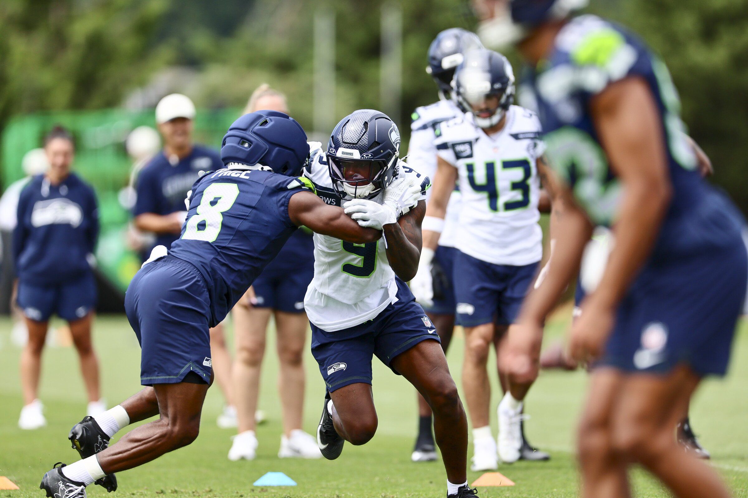 The Seahawks’ Jadarian Price, left, and Bud Clark participate in drills during training camp on Tuesday afternoon. (Kevin Clark / The Seattle Times)