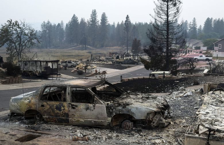 Burnt vehicles and homes remain after the Old Trails fire passed through on Sunday, Aug. 2, 2026, in Spokane. (Nick Wagner / The Seattle Times)