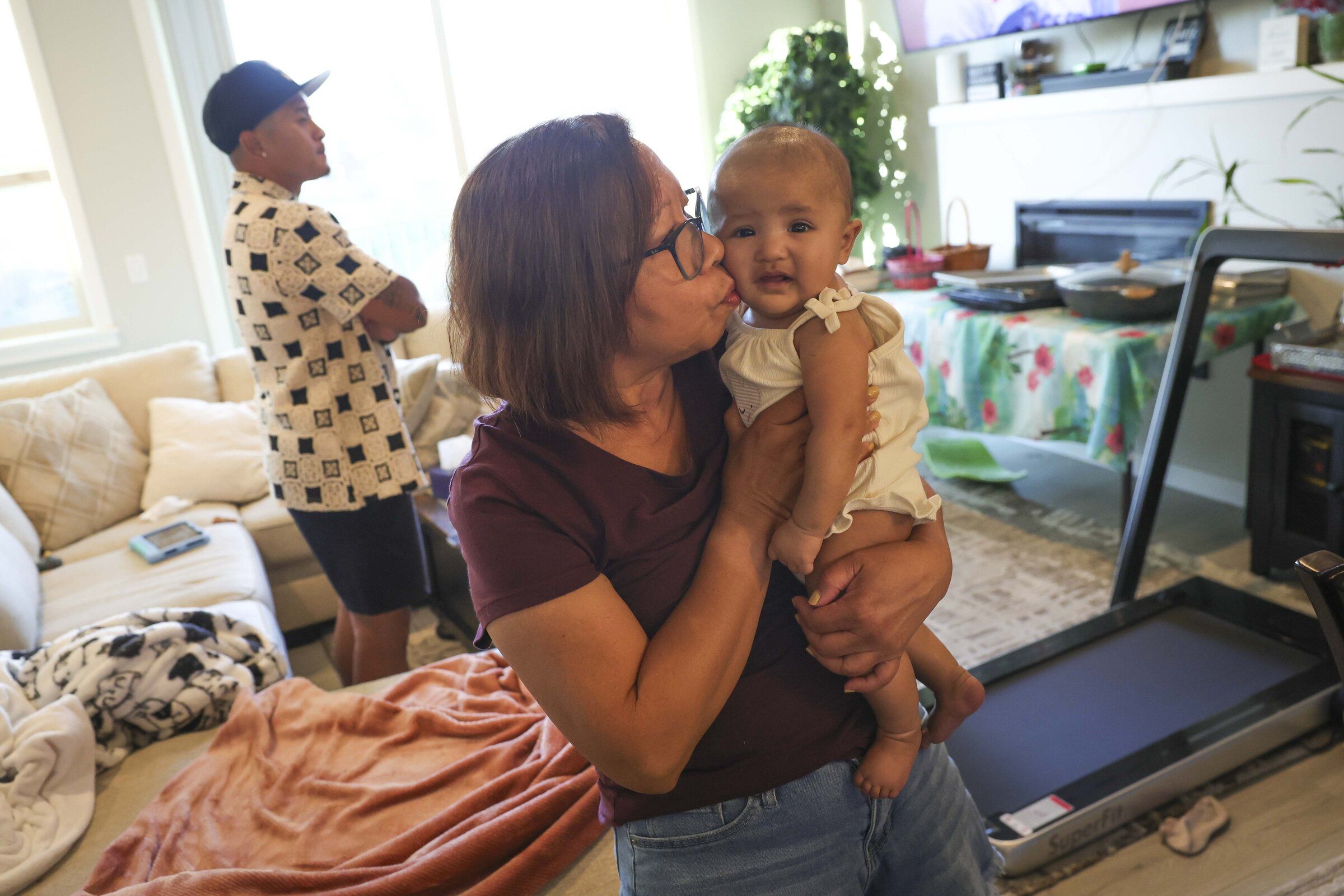 Lewelyn Dixon kisses her great-niece E’Layla, who is 4 months old, during a family gathering at home last month. (Ivy Seballo / The Seattle Times)