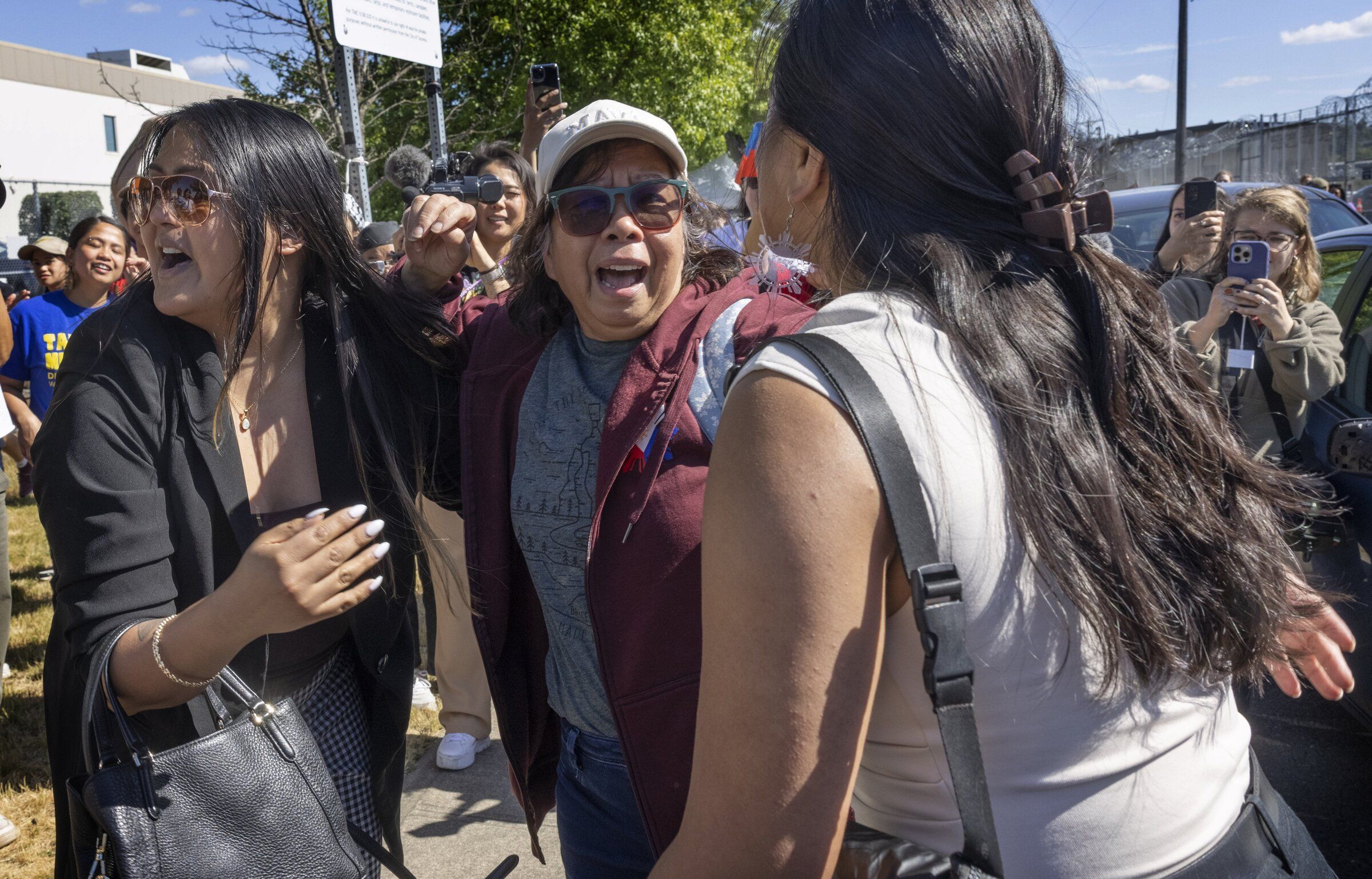 Longtime green card holder Lewelyn Dixon is surrounded by family members and supporters as she is released from the Northwest ICE Processing Center in Tacoma in May 2025. (Ellen M. Banner / The Seattle Times)
