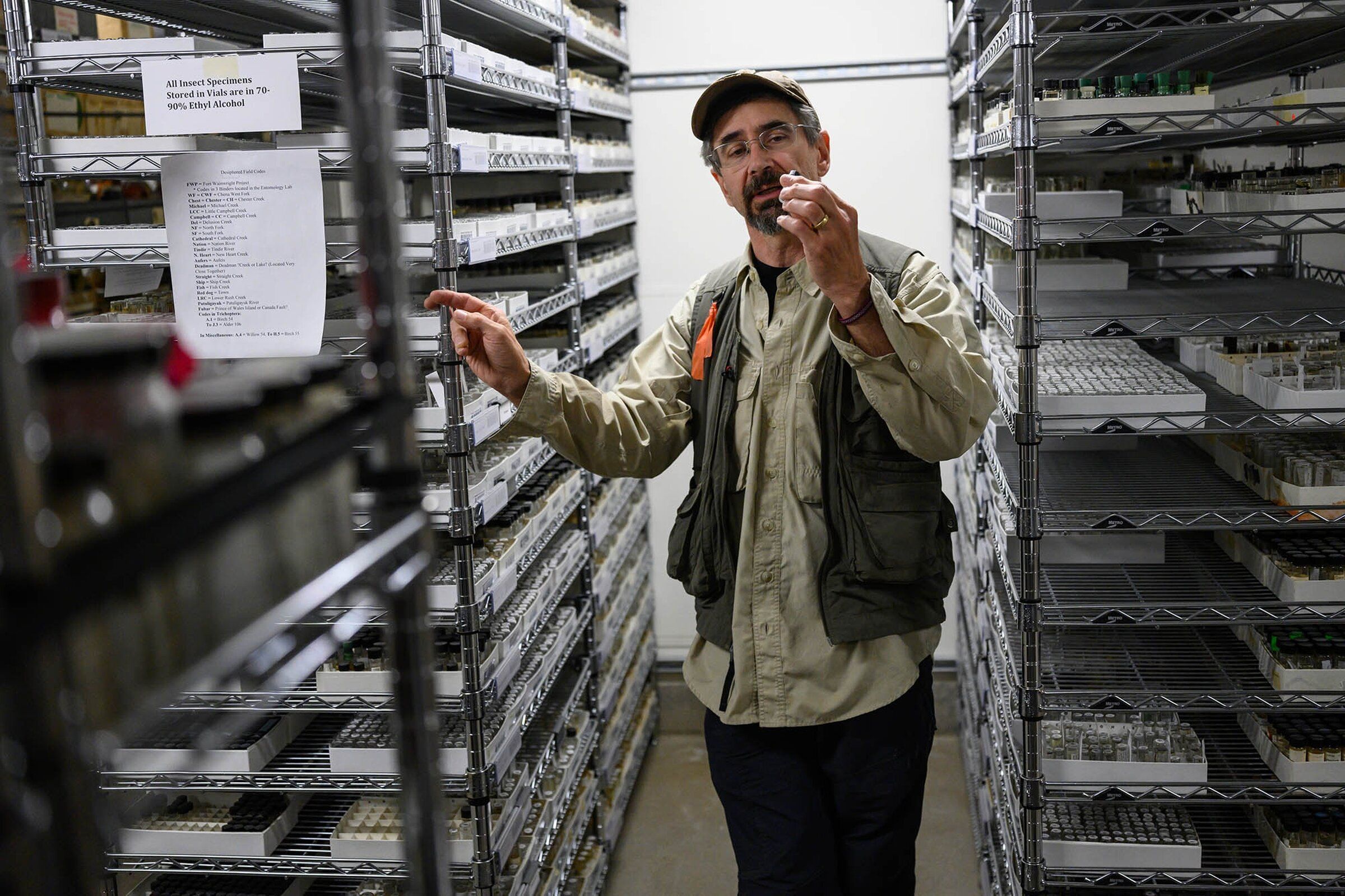 Derek Sikes, curator of insects for the University of Alaska Museum of the North and a professor of entomology, holds a vial in a storage area of the museum’s collection July 14. (Marc Lester / Anchorage Daily News)