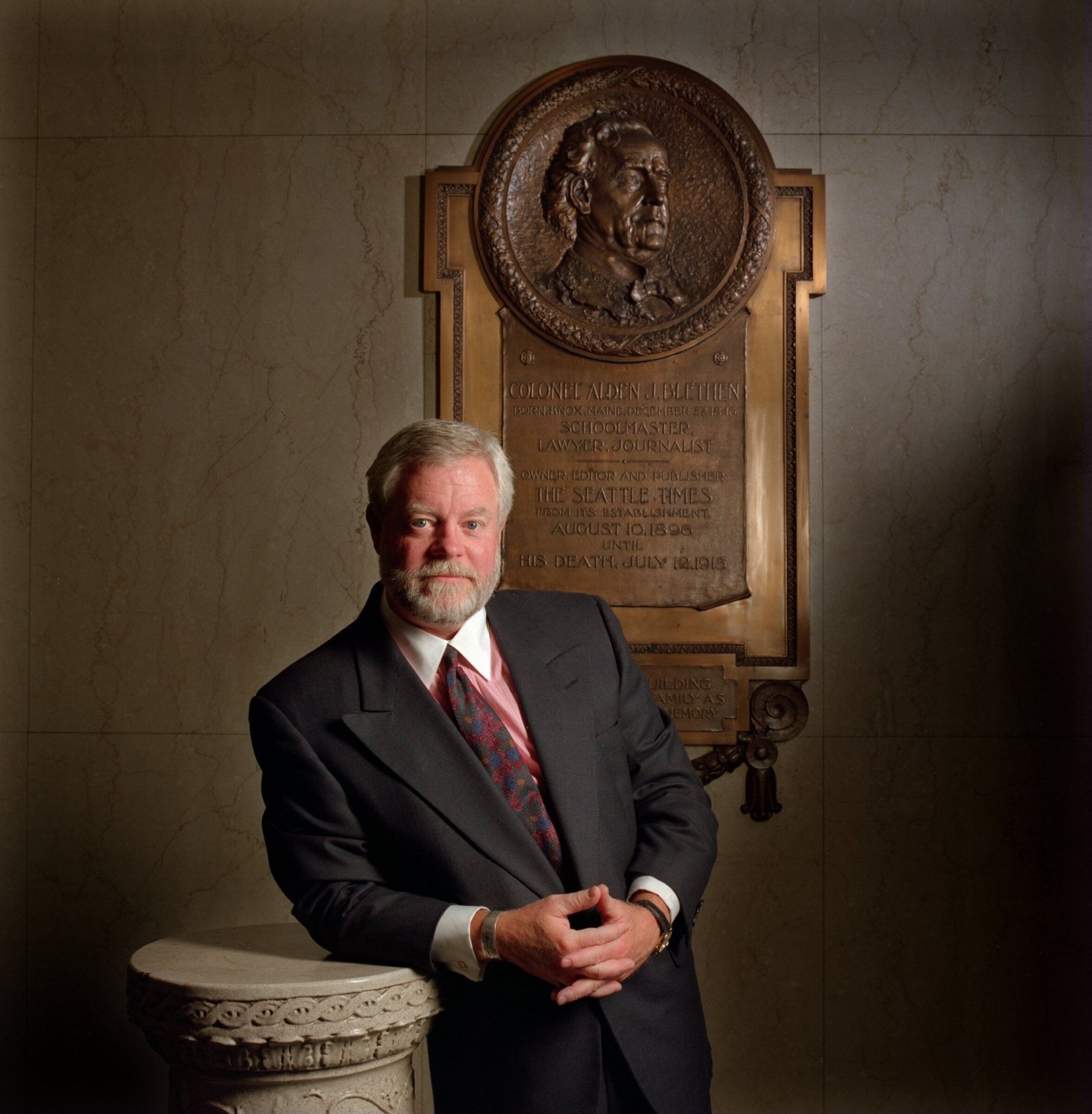 In 1996, on the occasion of the newspaper’s centennial, Frank Blethen, the seventh publisher of The Seattle Times, stands beside a memorial to Col. Alden J. Blethen, the newspaper’s first publisher. The memorial now hangs at the entrance to the newsroom. (Benjamin Benschneider / The Seattle Times, 1996)