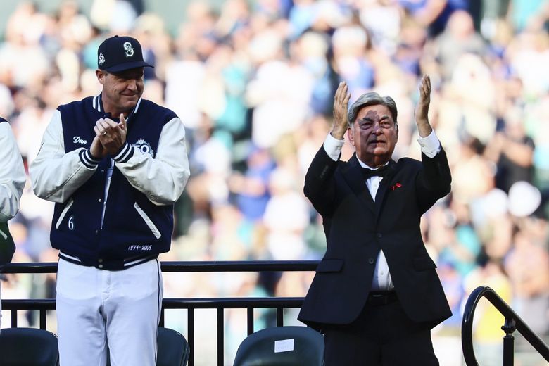 Seattle Mariners manager Dan Wilson applauds broadcaster Rick Rizzs after he is accepted into the Mariners Hall of Fame during a pregame celebration on Saturday marking 50 seasons of the baseball club. (Kevin Clark / The Seattle Times)