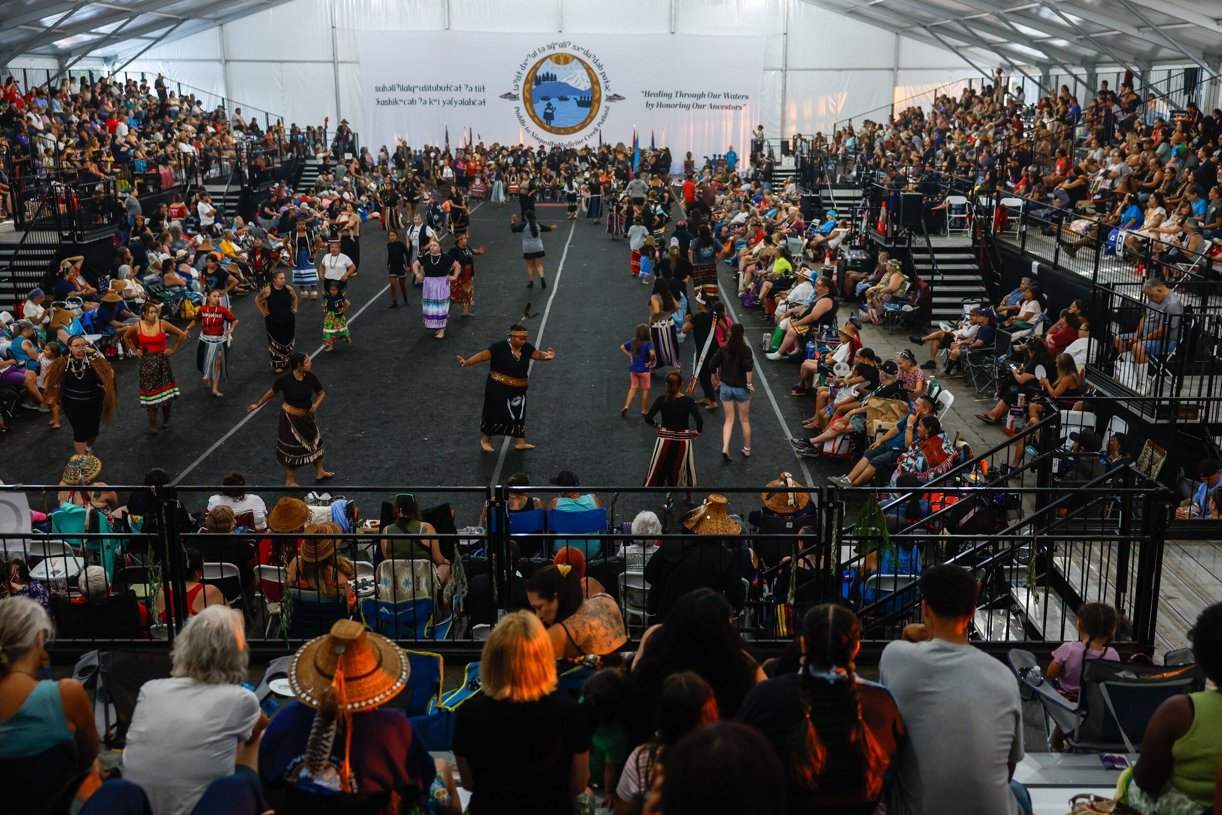 The Muckleshoot Tribe’s canoe family performs during protocol at the 2026 Paddle to Nisqually — Medicine Creek potlatch hosted by the Nisqually Tribe on Wednesday, Aug. 5. (Andrew Burk-Stephenson / The Seattle Times)