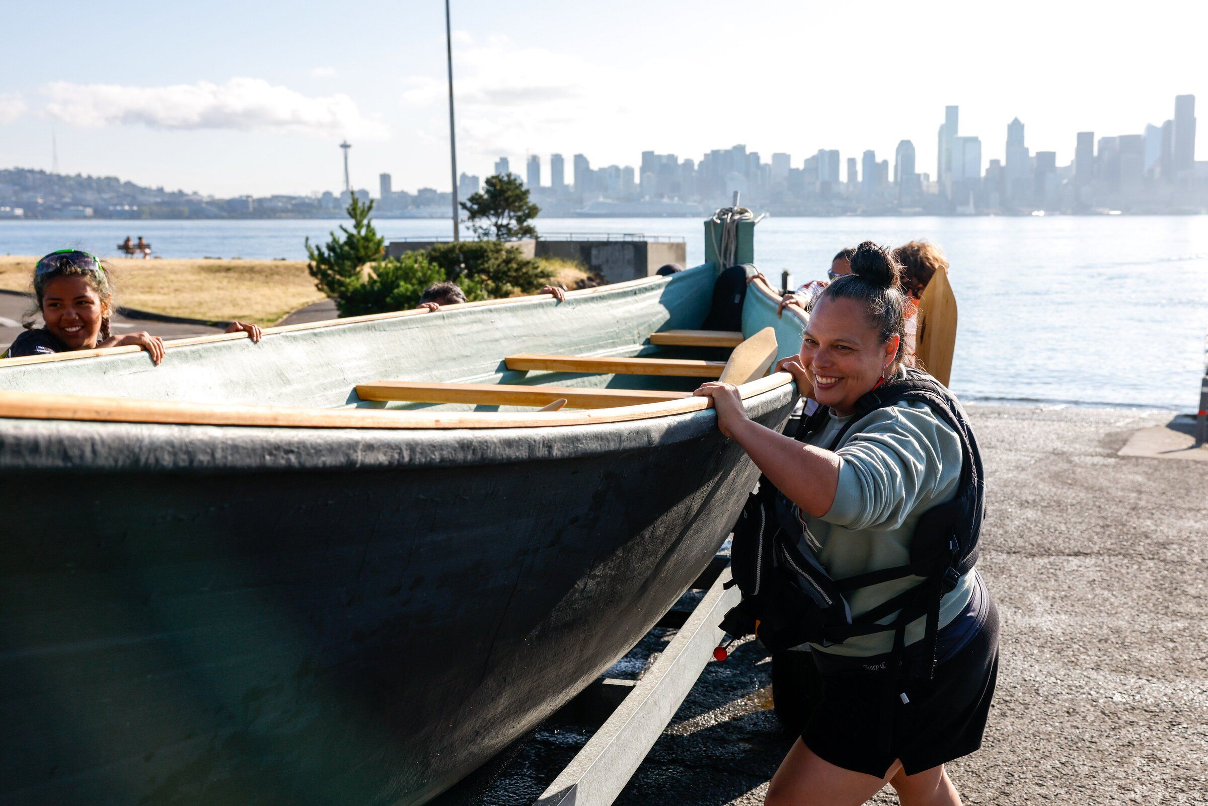 Autumn MaGee helps push the canoe tubšadad səli (Warrior Spirit) at the Don Armeni boat ramp in West Seattle as canoes depart from Alki Beach for Puyallup across the Salish Sea on Thursday, July 30. The previous day, young members of the Muckleshoot Tribe’s canoe family had pulled the canoe from Suquamish to Alki Beach. (Andrew Burk-Stephenson / The Seattle Times)