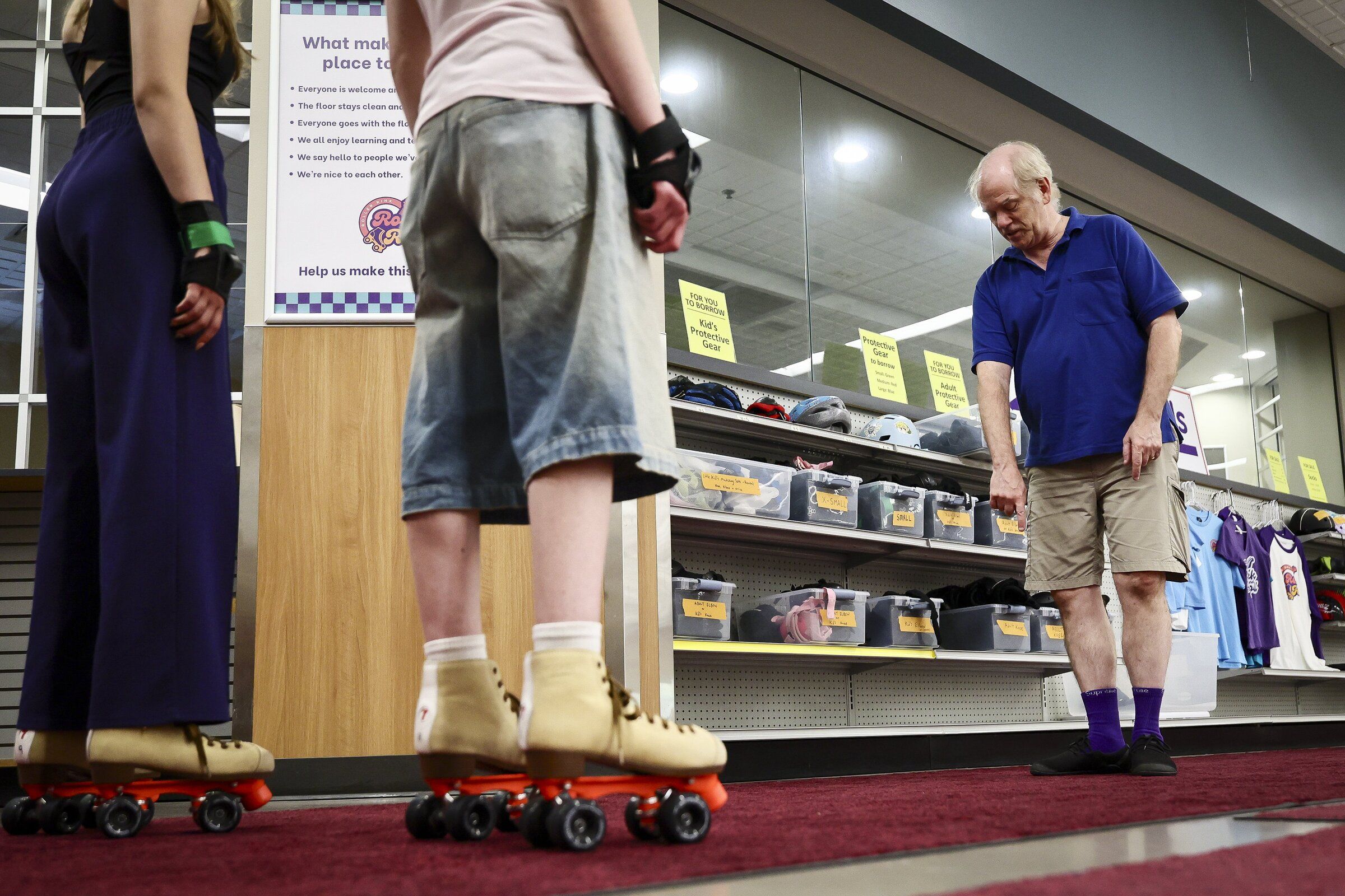 Ed Mills, right, leads a skating lesson at Rock and Roll Roller Rink in Issaquah. He is also the treasurer of the nonprofit organization. (Kevin Clark / The Seattle Times)