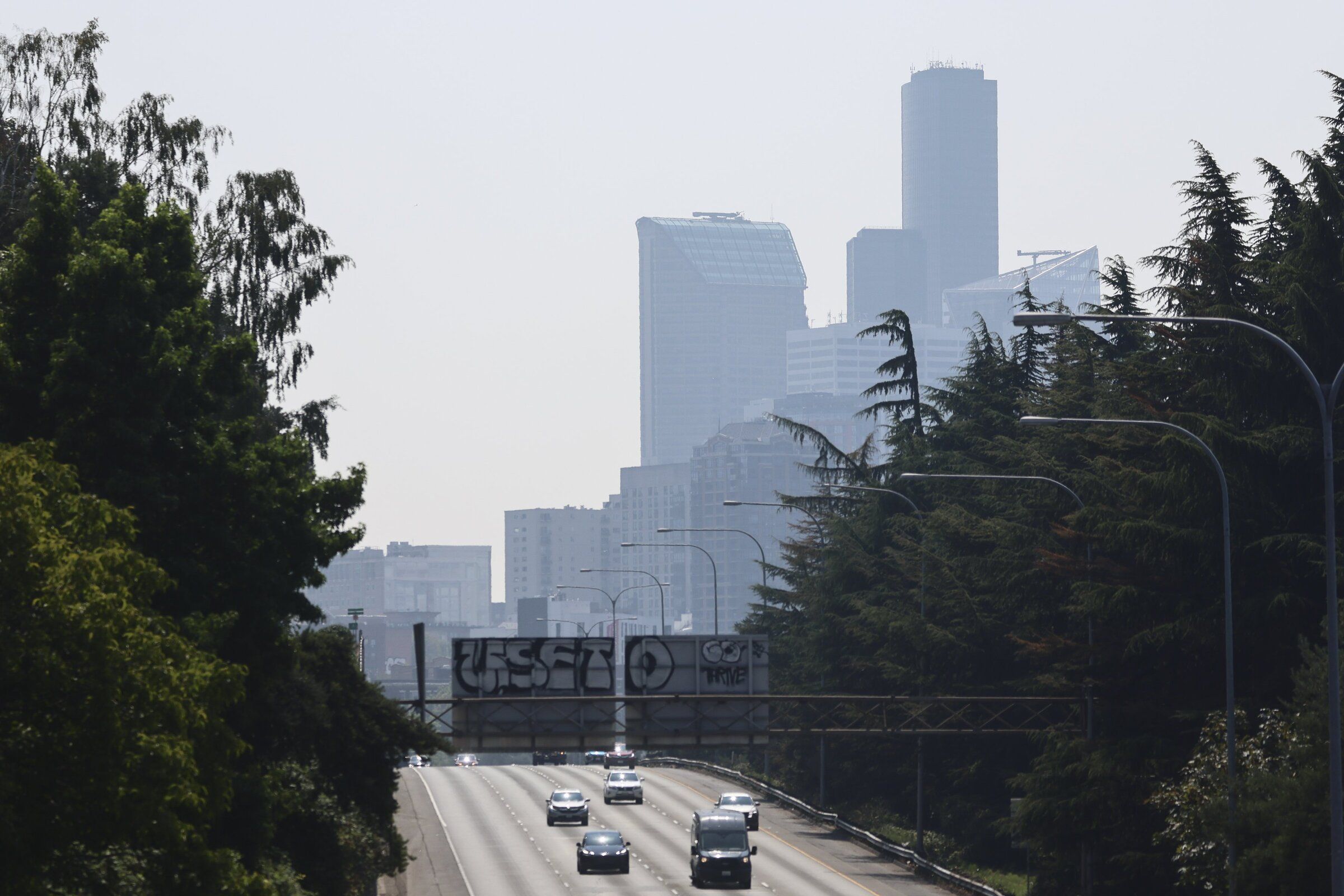 Downtown Seattle is seen through last week’s smoke haze. A new weather system will pull smoke from British Columbia wildfires, but it won’t be any more noticeable than a tinge to the sunrise and sunset. (Kevin Clark / The Seattle Times)