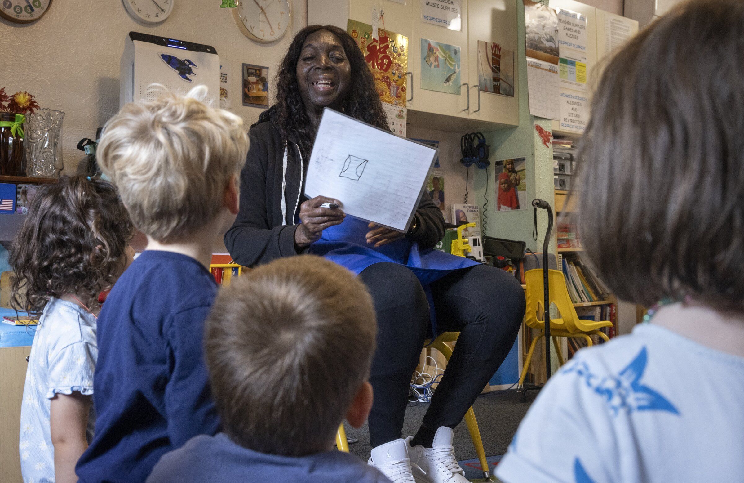 Luida Foster, a preschool teacher at Community Day Center for Children in Seattle’s Central District, teaches her students how to count to ten in Mandarin. (Ellen M. Banner / The Seattle Times, 2025)